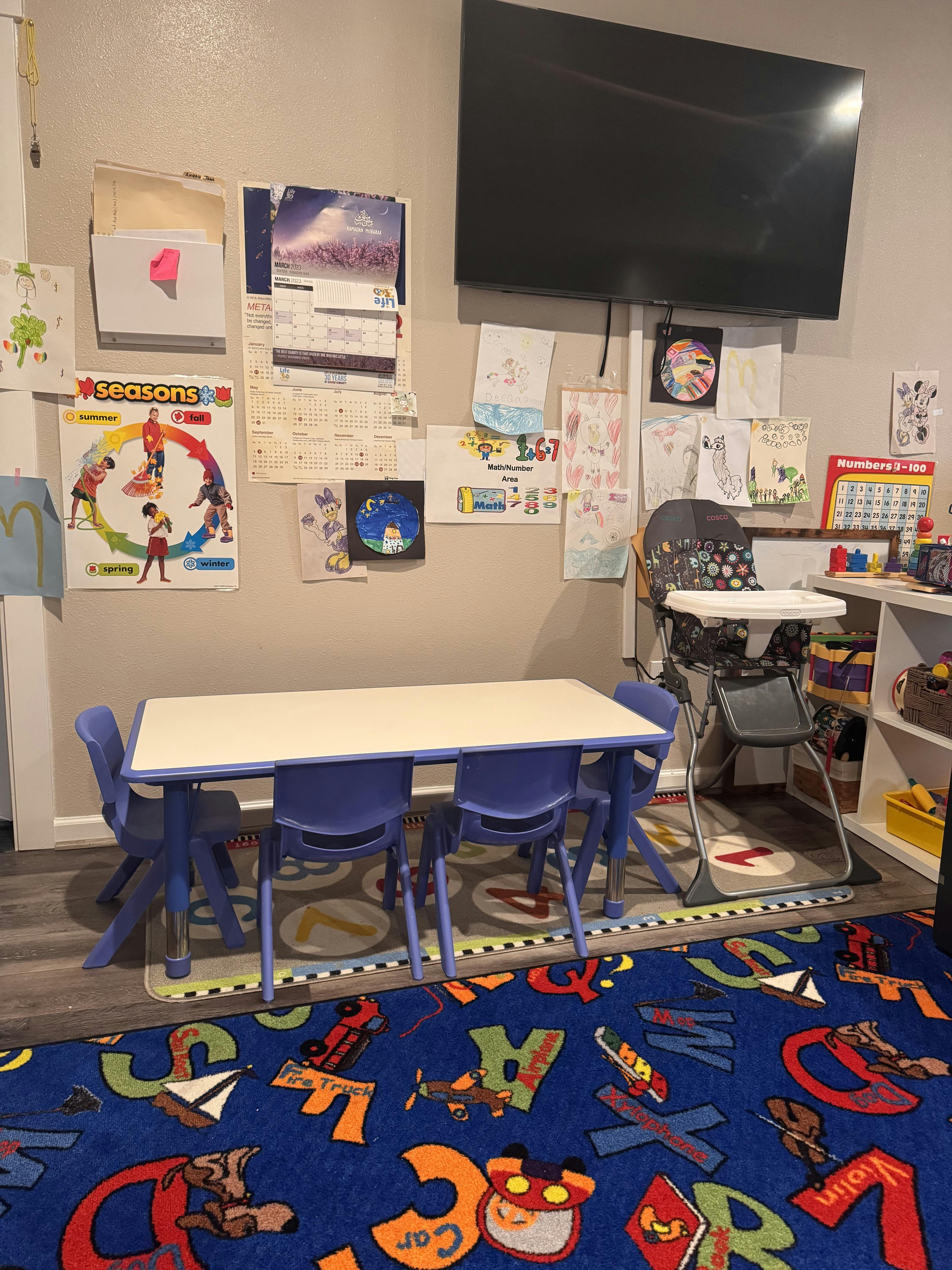 Children's table and chairs in a room with a large alphabet rug