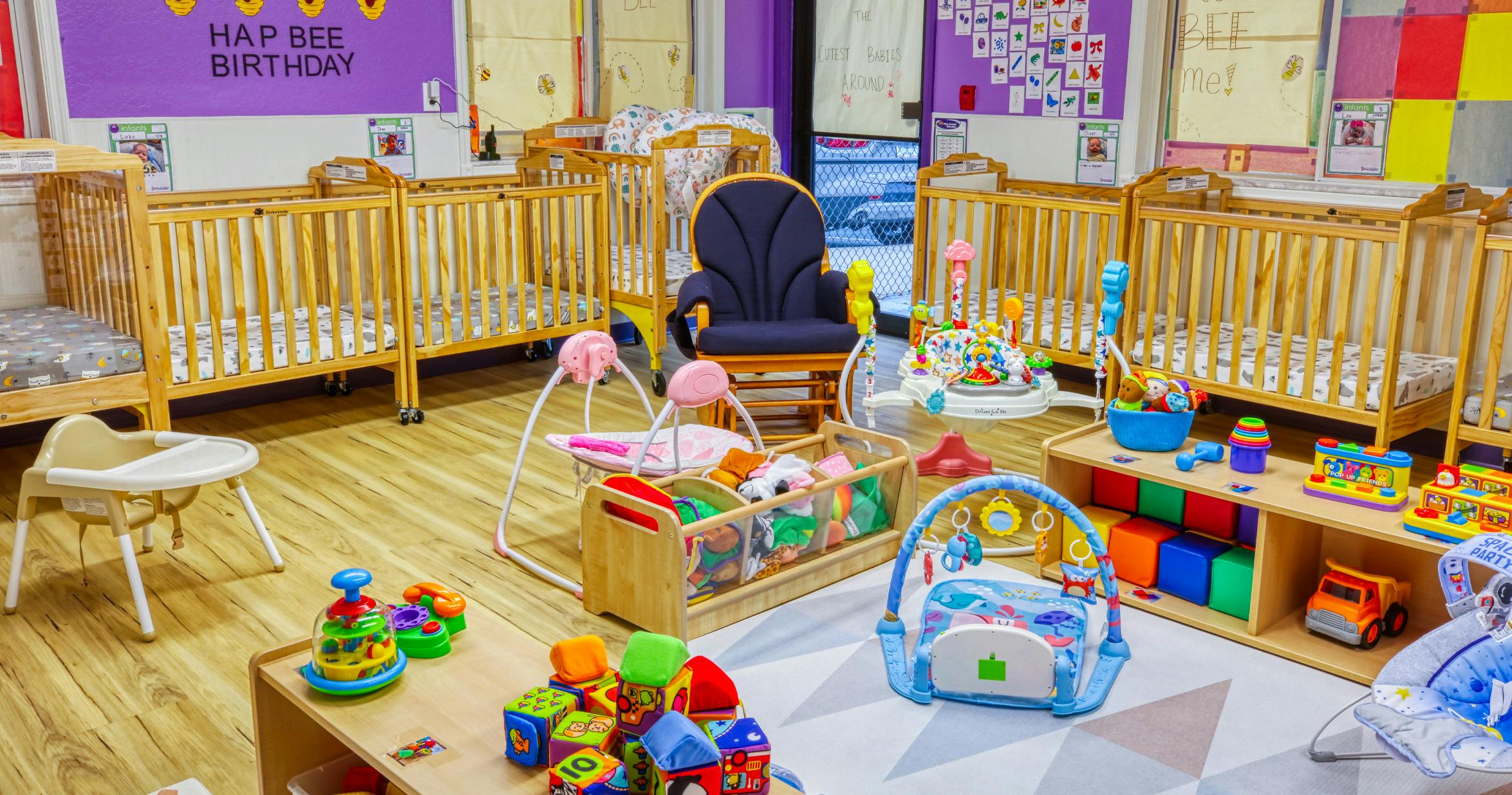 cribs, toys, and infant equipment in a colorful room