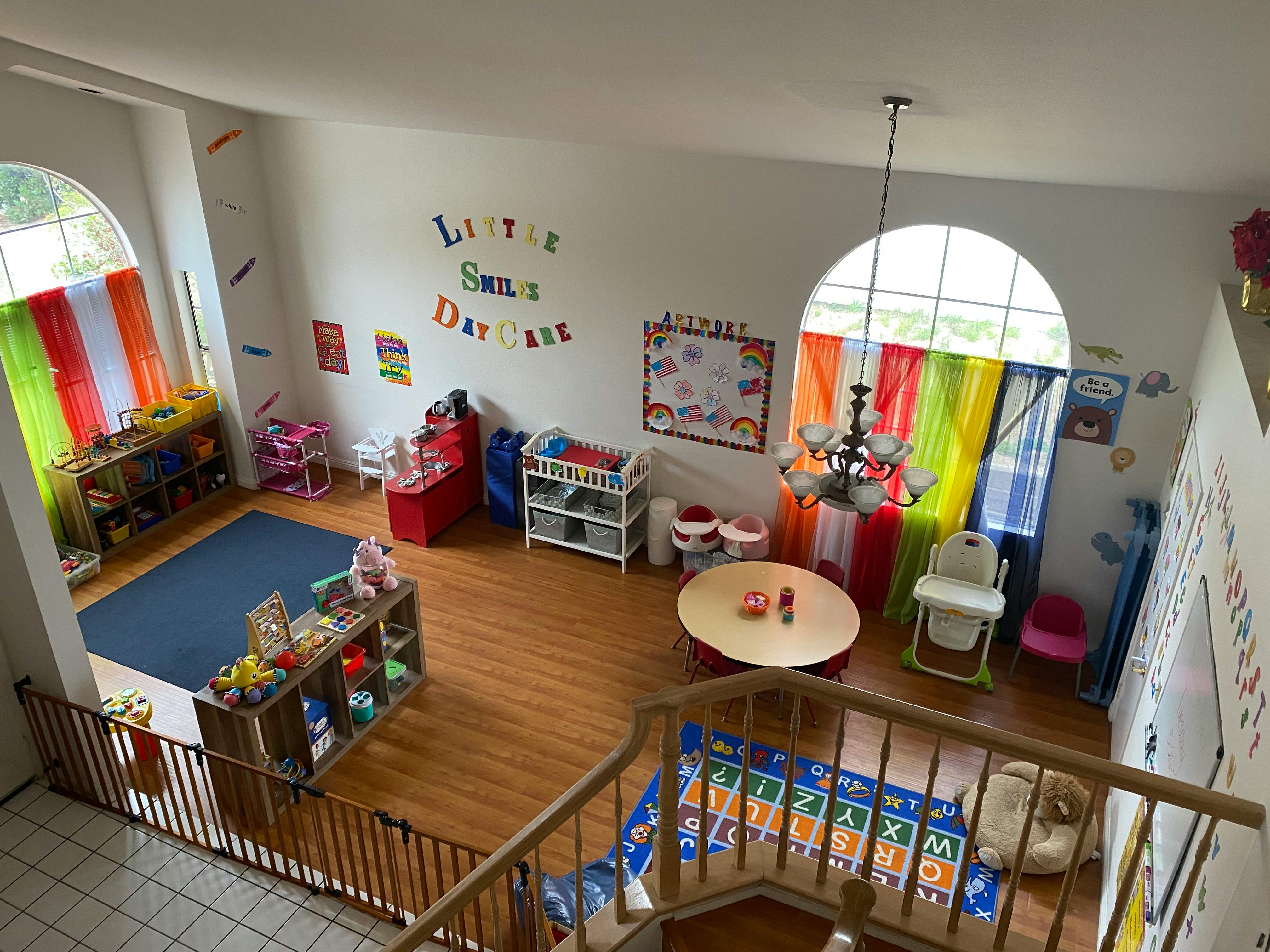 Daycare room with colorful curtains, toys, and small tables
