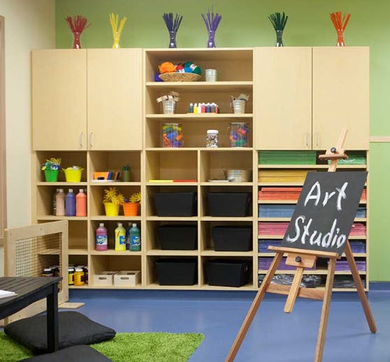 Art studio with shelves of supplies and an easel with "Art Studio" written on it