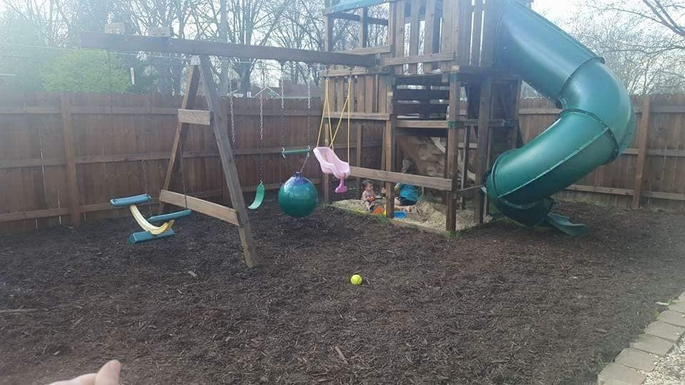 Outdoor playground with swings and a green slide