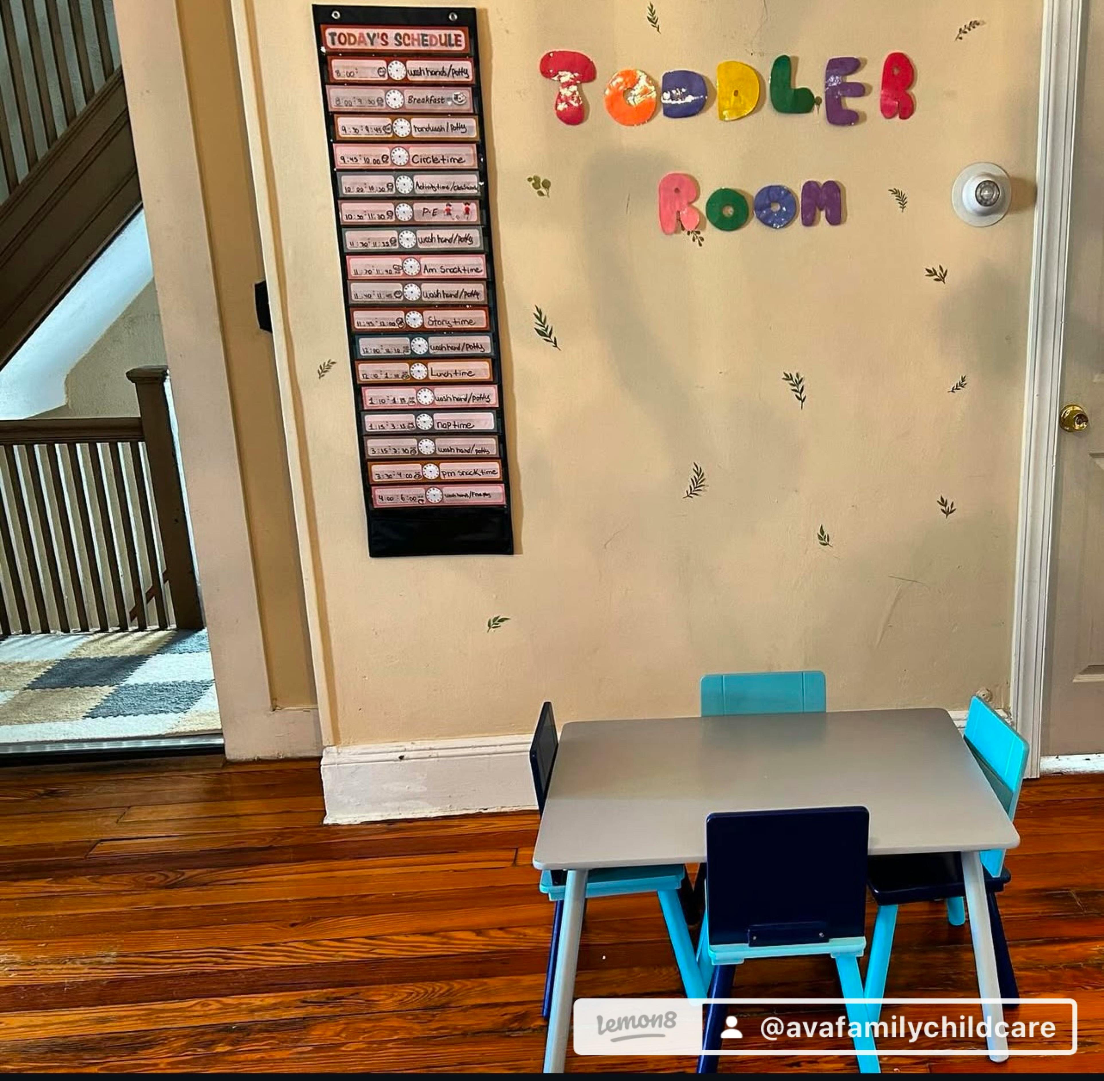 Toddler room with small table and chairs, schedule chart on wall
