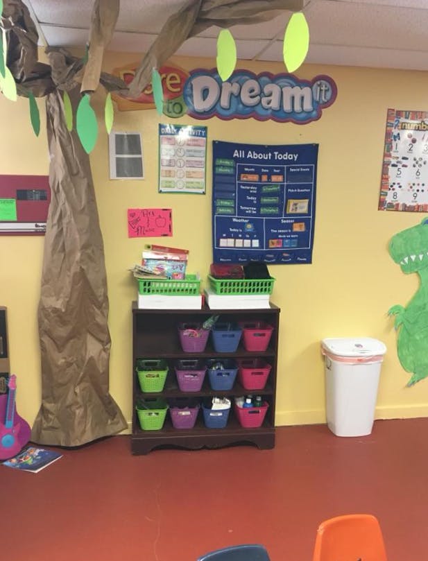 Classroom with a paper tree, storage shelf, and wall decorations