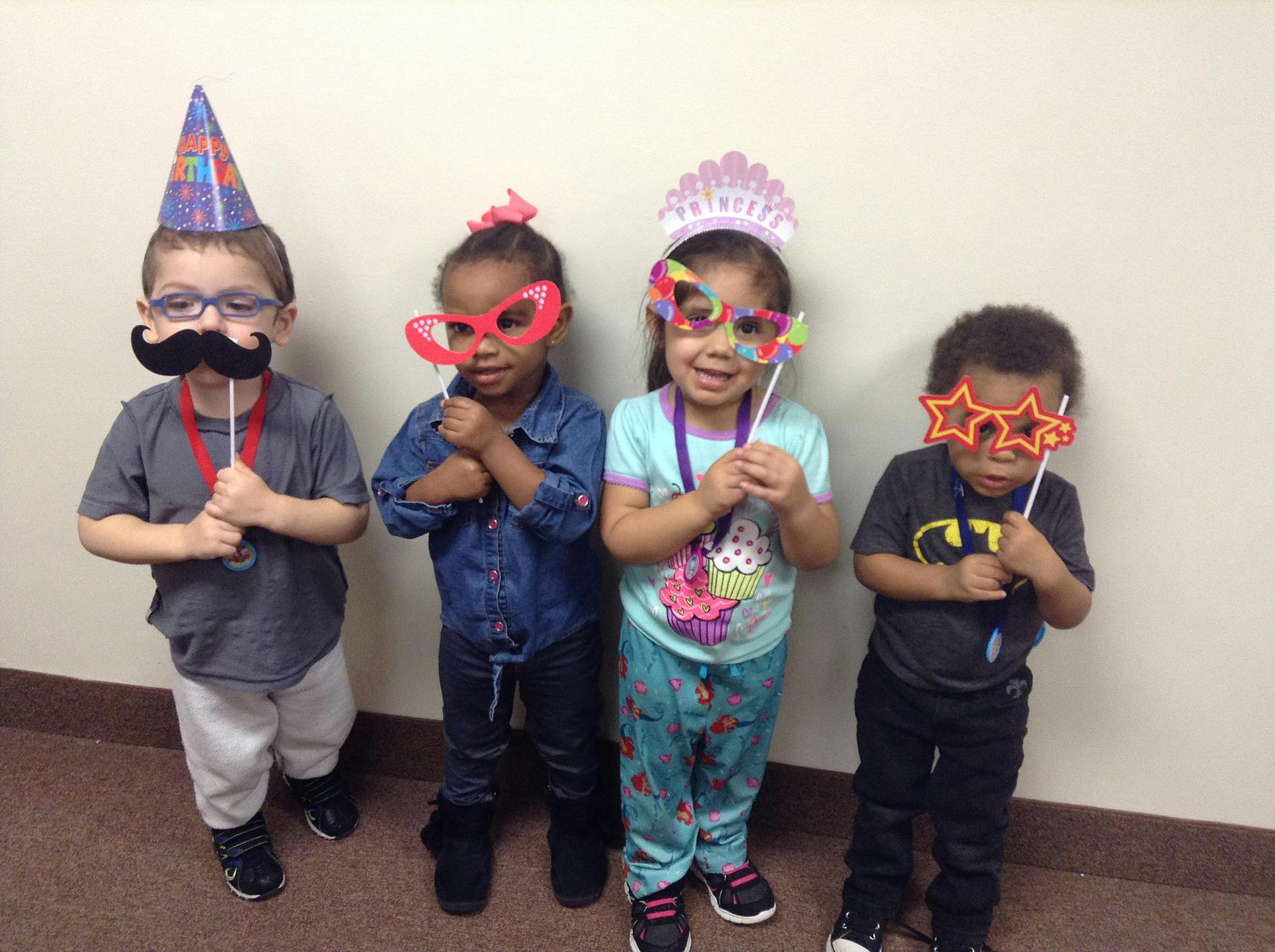 Four children holding up photo booth props