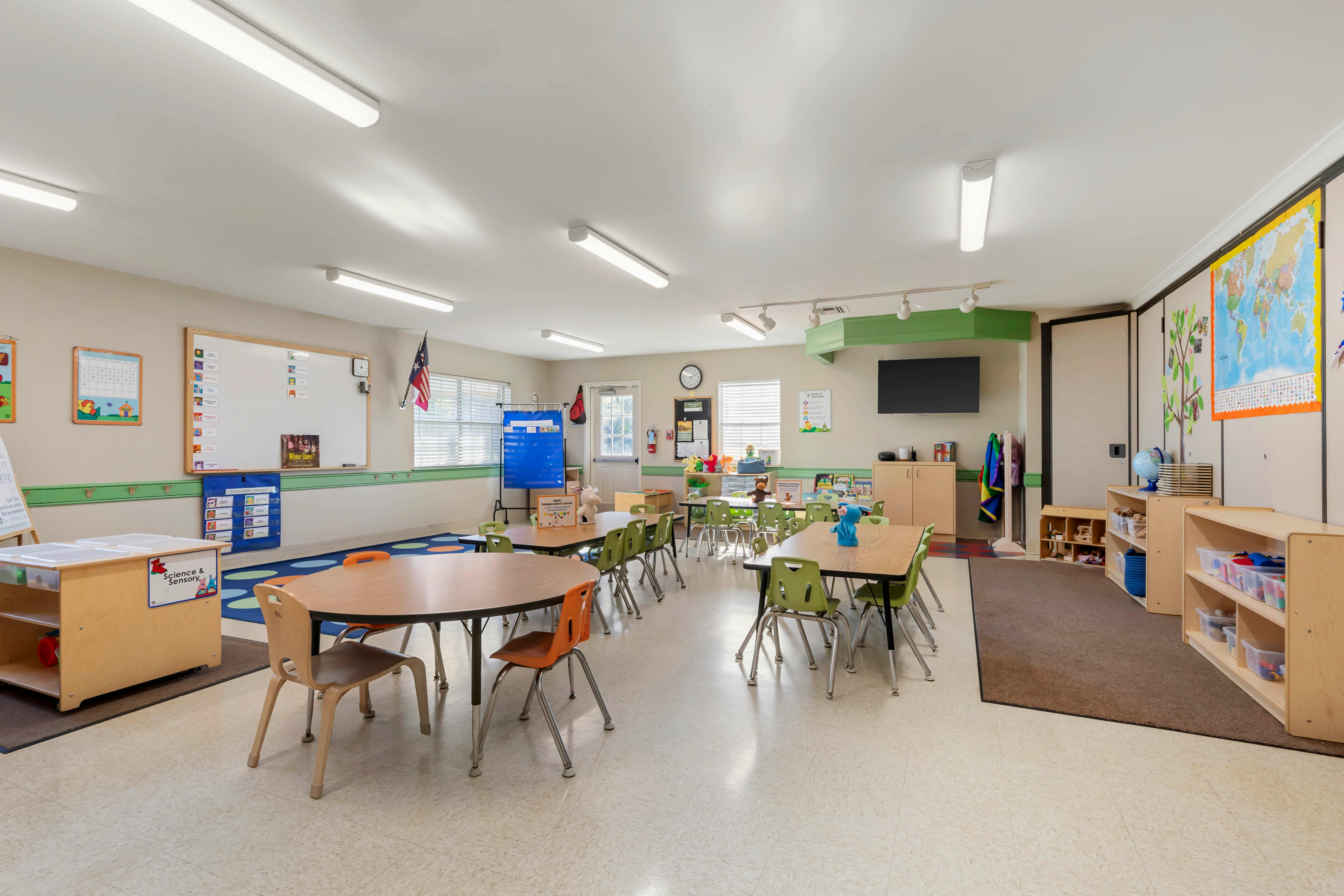 Empty preschool or kindergarten classroom with tables and chairs