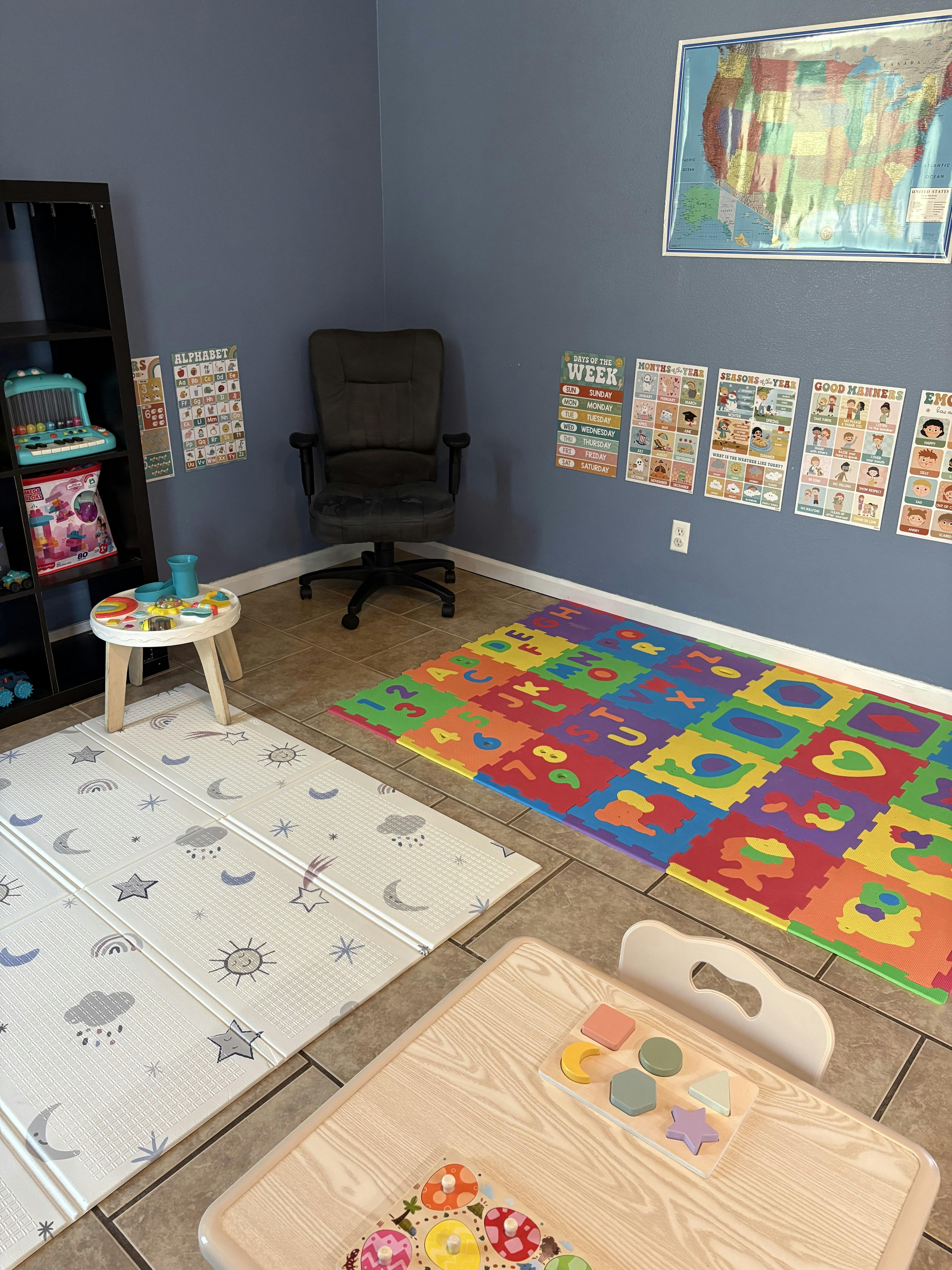 Playroom with colorful alphabet mat and small table