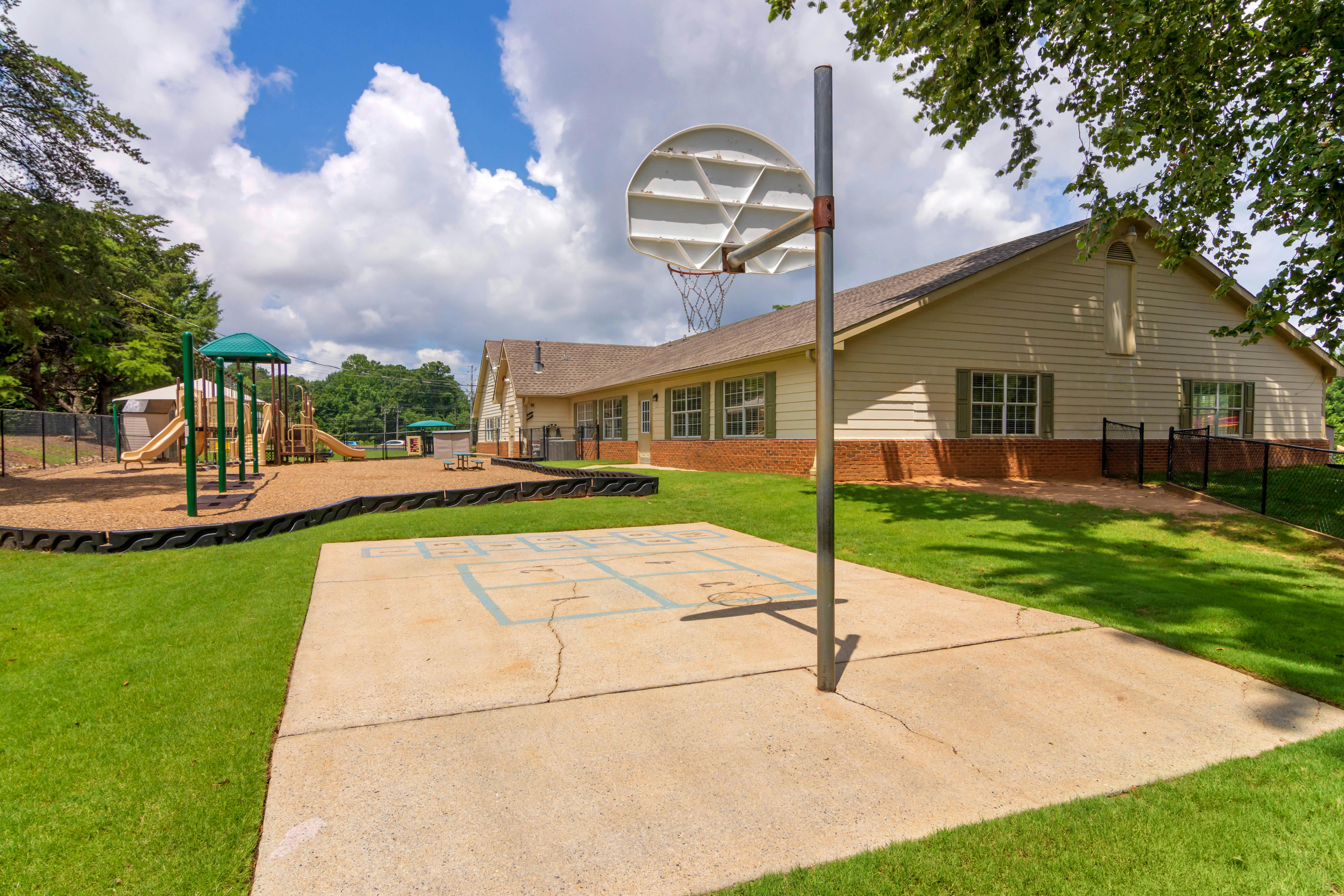 Basketball hoop on a concrete slab next to a playground