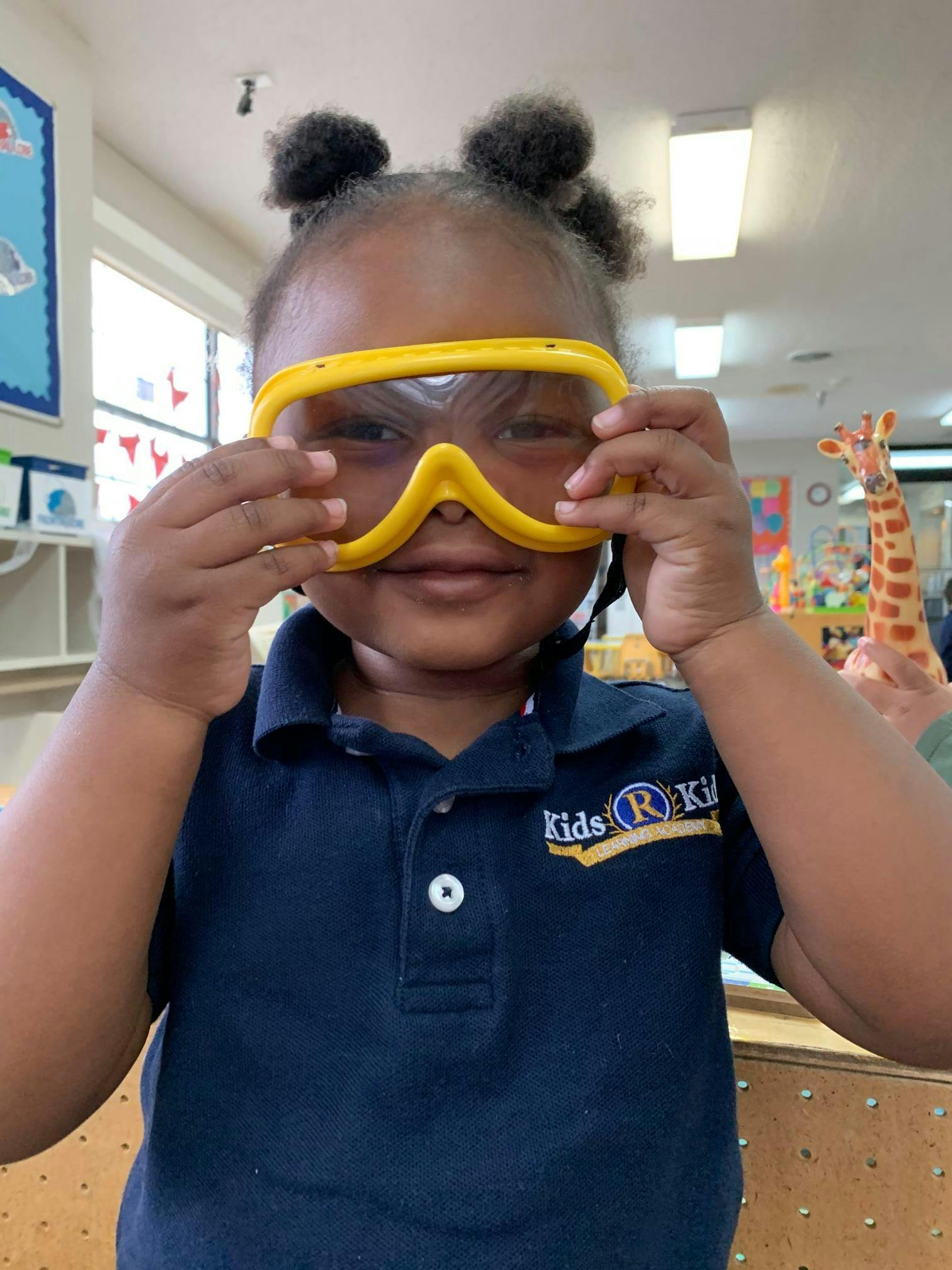 Child wearing yellow safety goggles