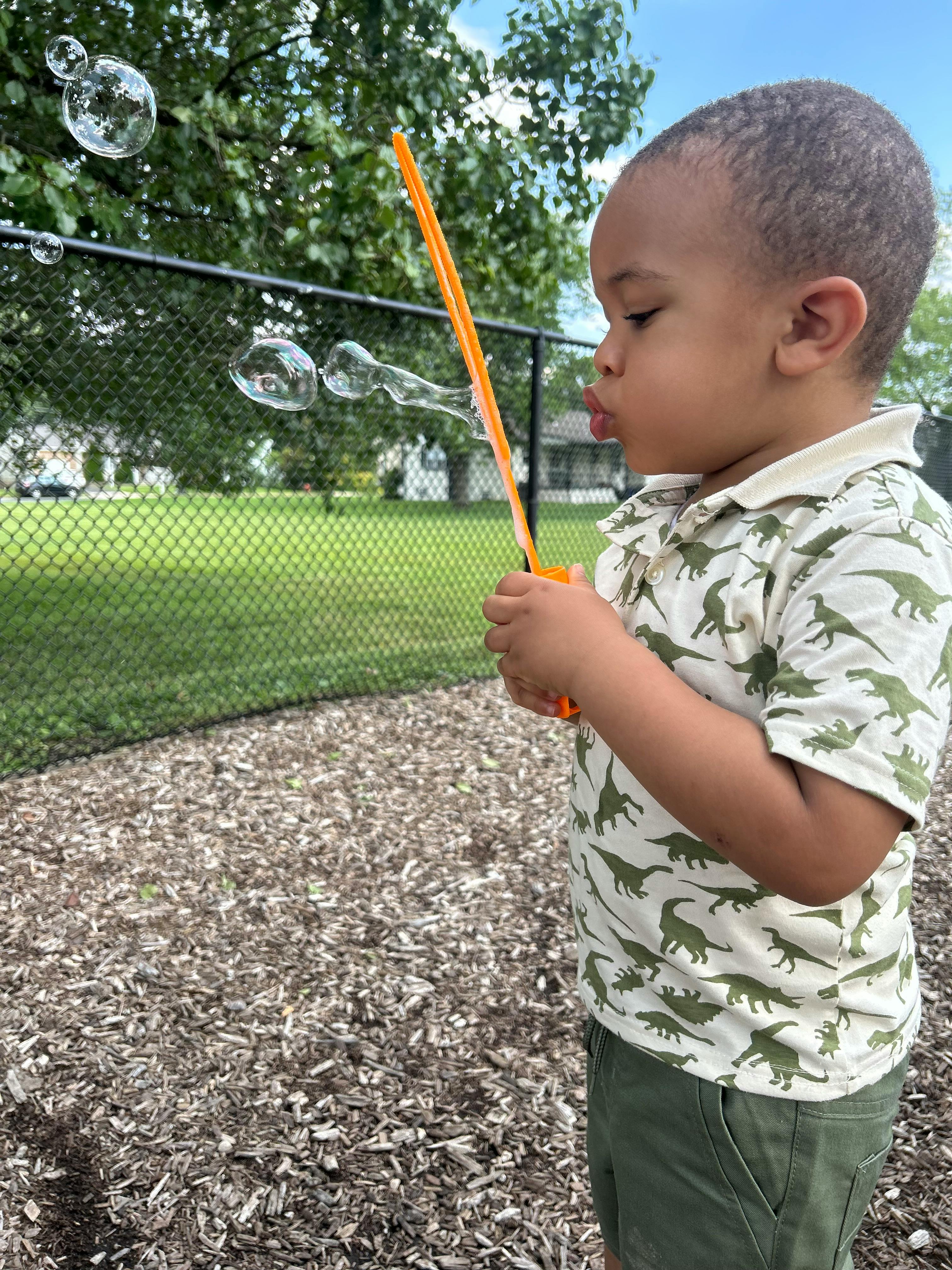 Child blowing bubbles outdoors