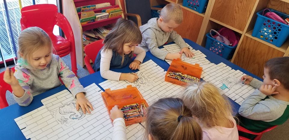 Children drawing at a table in a classroom