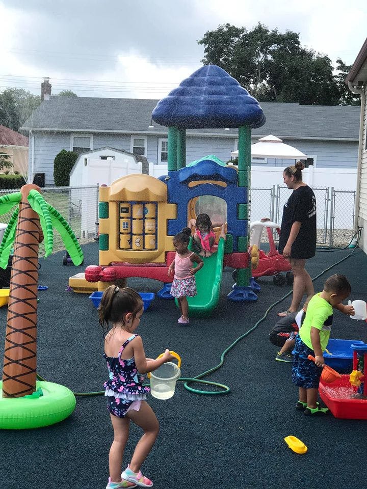 Children playing on a playground with a person supervising