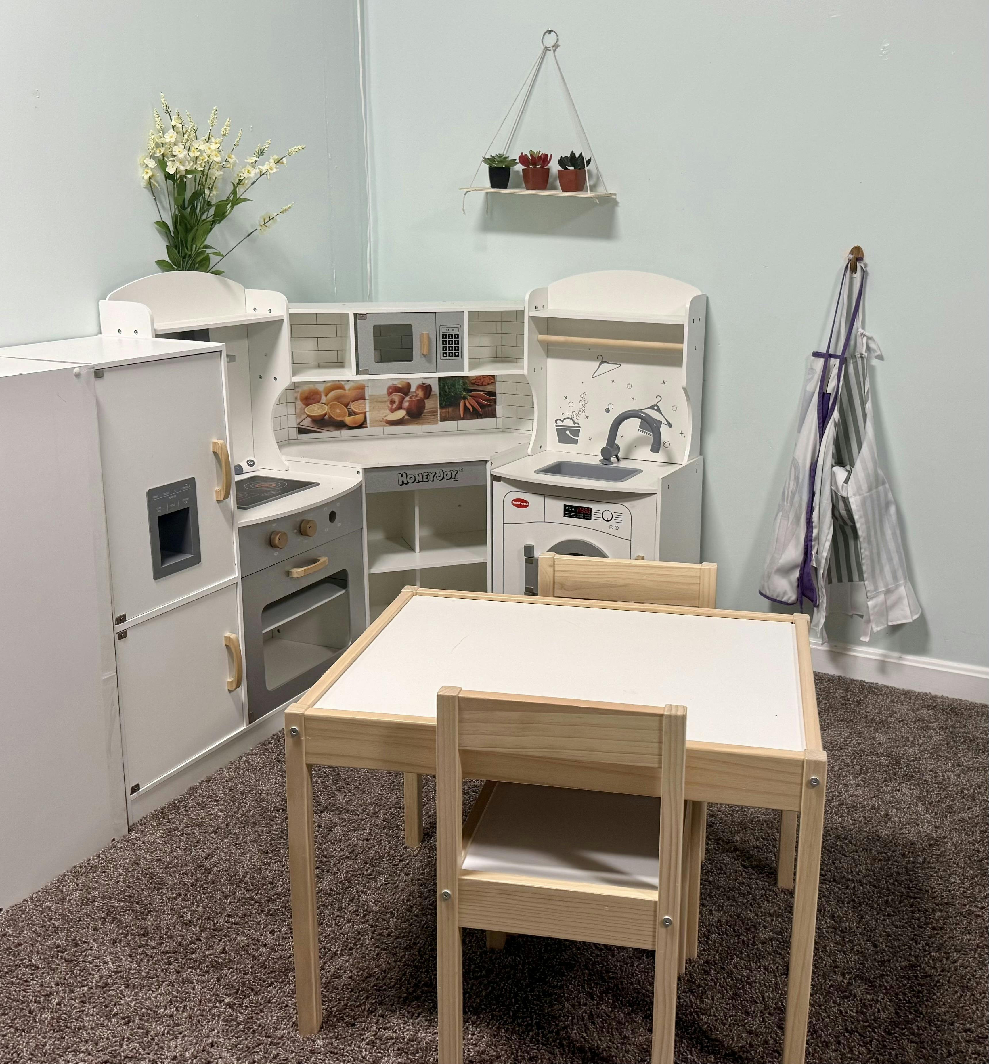 Children's play kitchen with a small table and two chairs