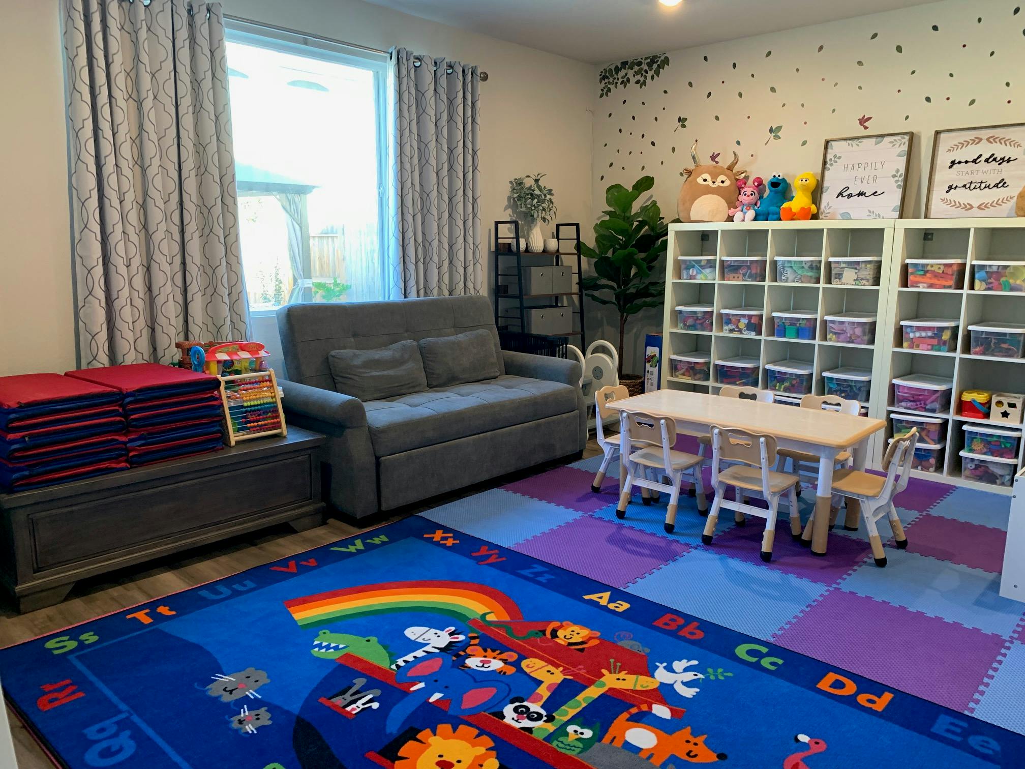 Playroom with a sofa, small table and chairs, and storage shelves