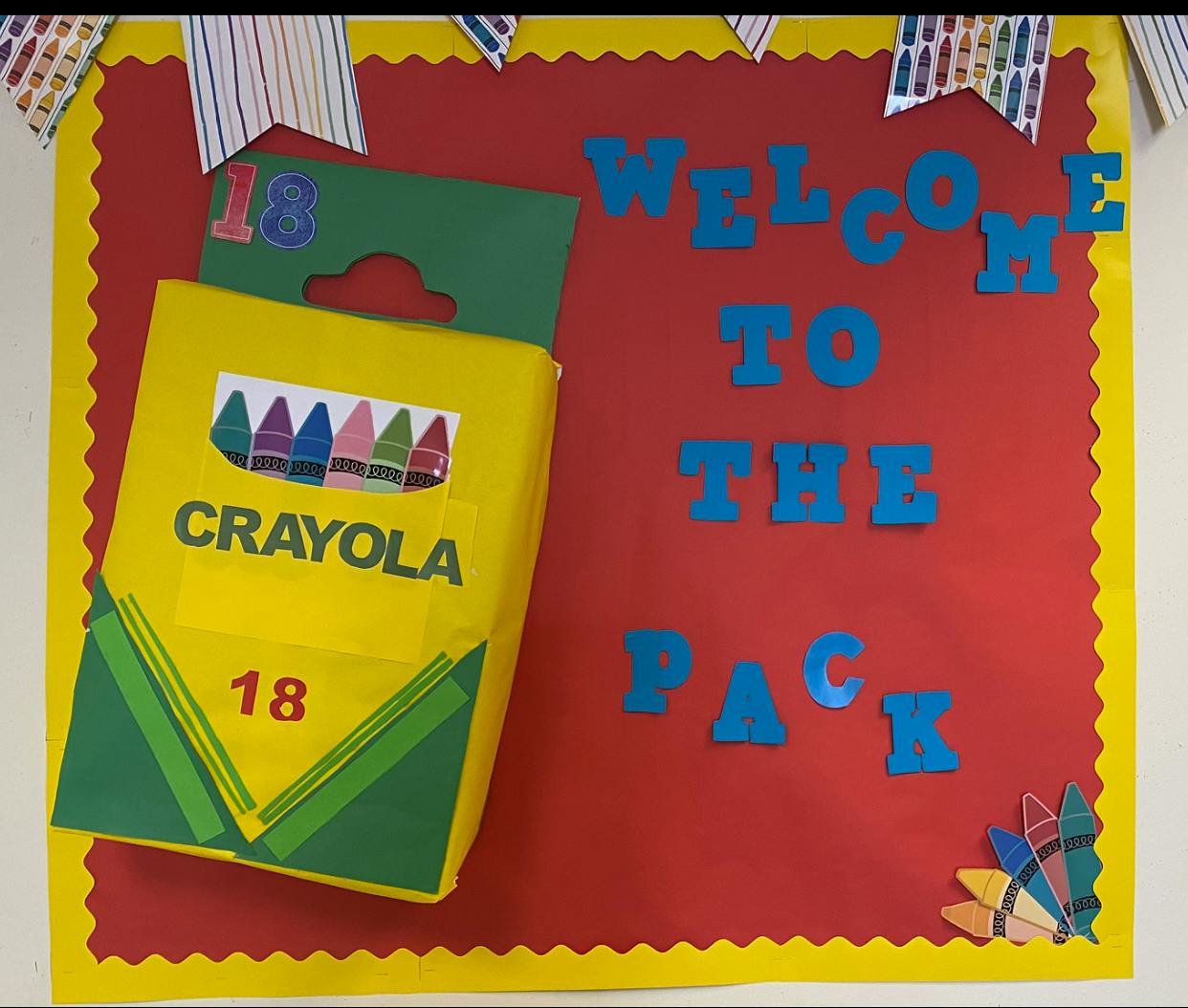 Crayola crayon box and "Welcome to the Pack" text on a bulletin board