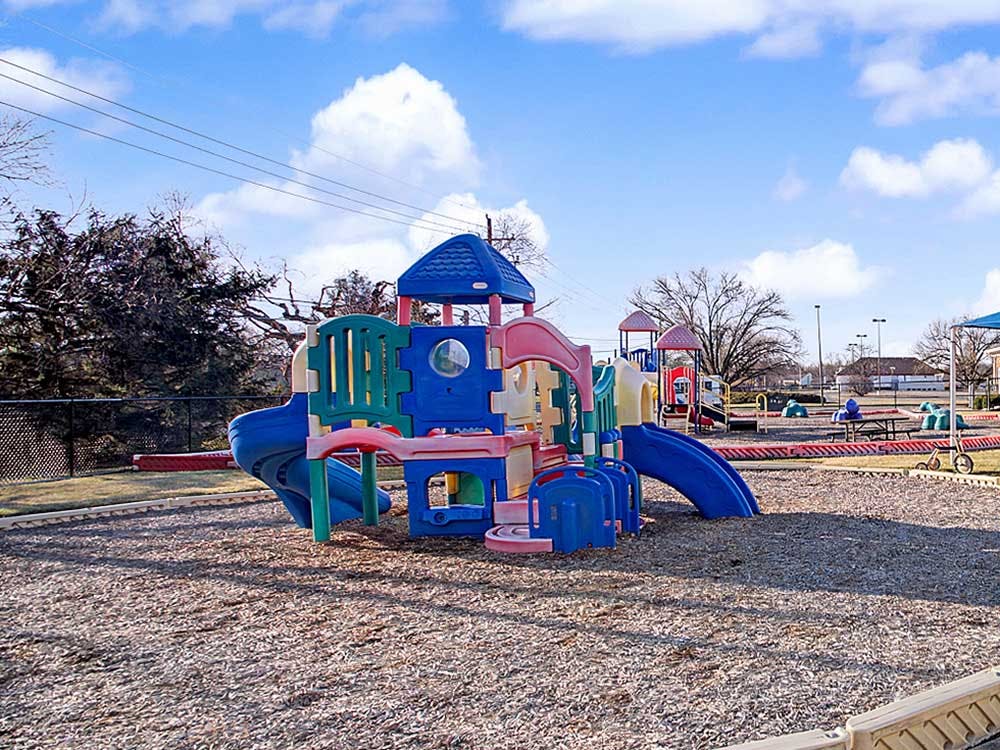 Colorful playground structure on wood chips under a blue sky