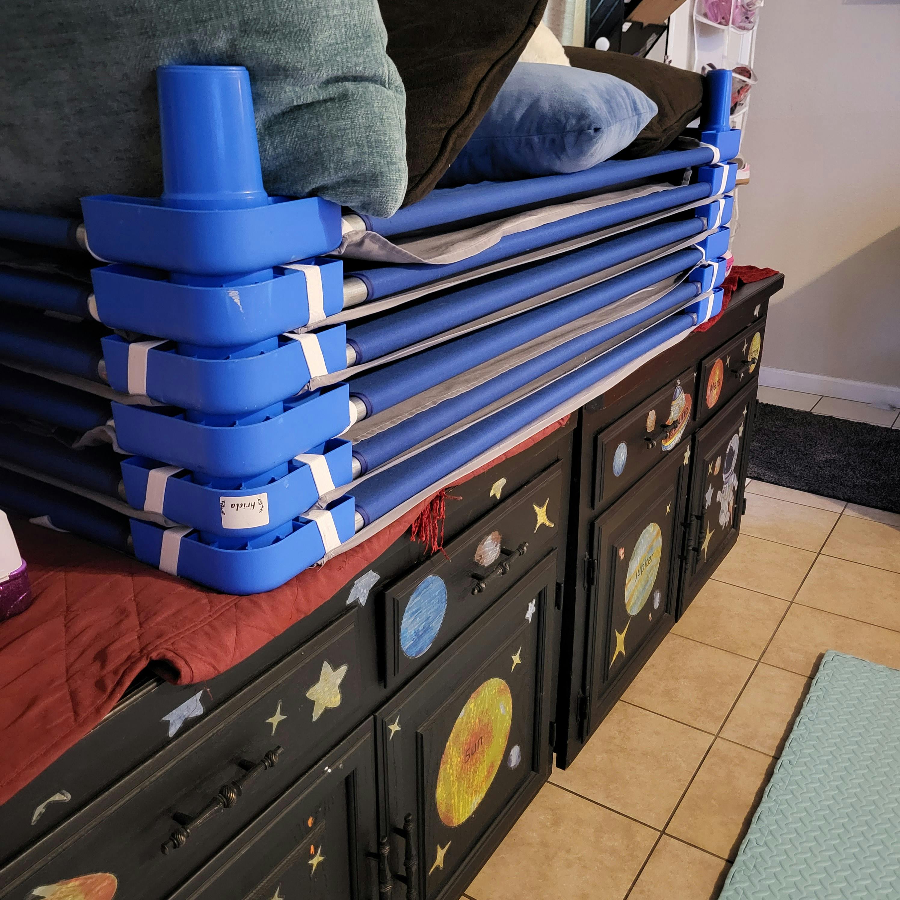 Blue and white mat rolls stacked next to black furniture with planet drawings