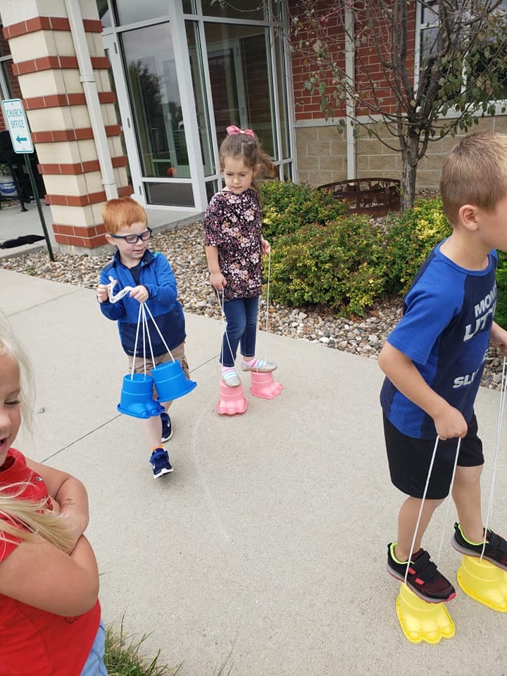 Children walking with bucket stilts