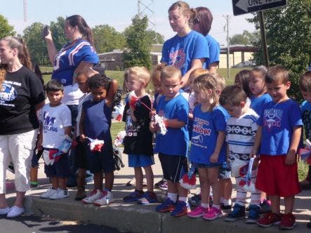 Adults and children standing on a curb