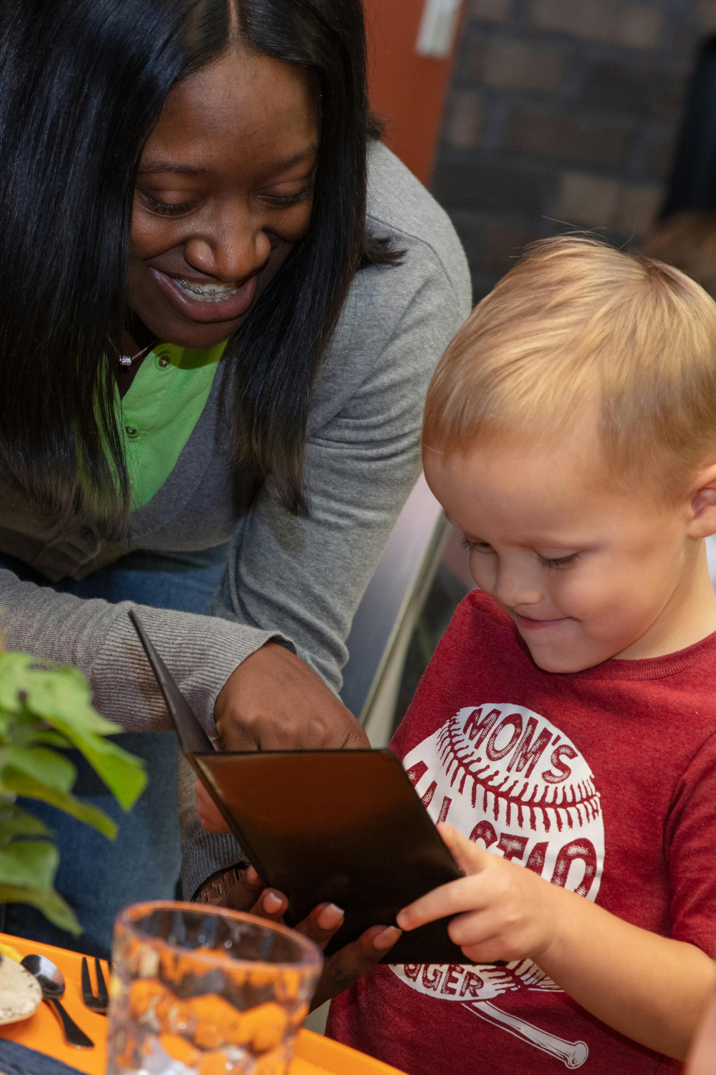 Person and child looking at a tablet