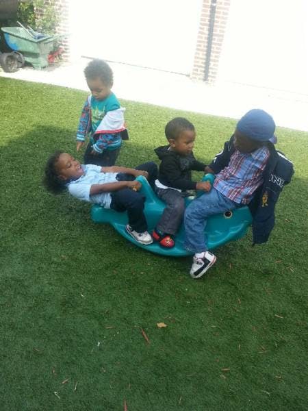 Children playing on a seesaw on grass