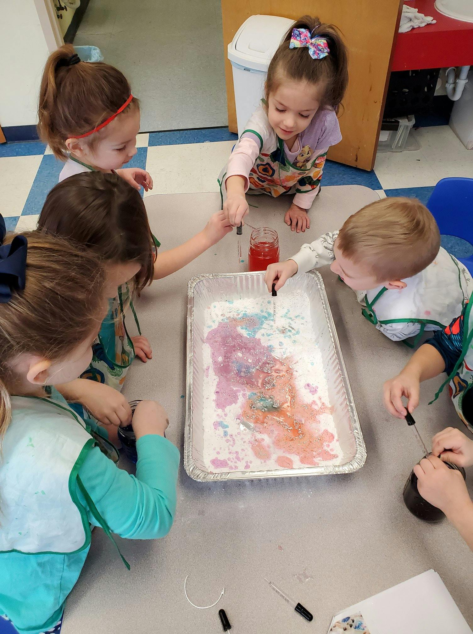Children using droppers to add colored liquid to a tray