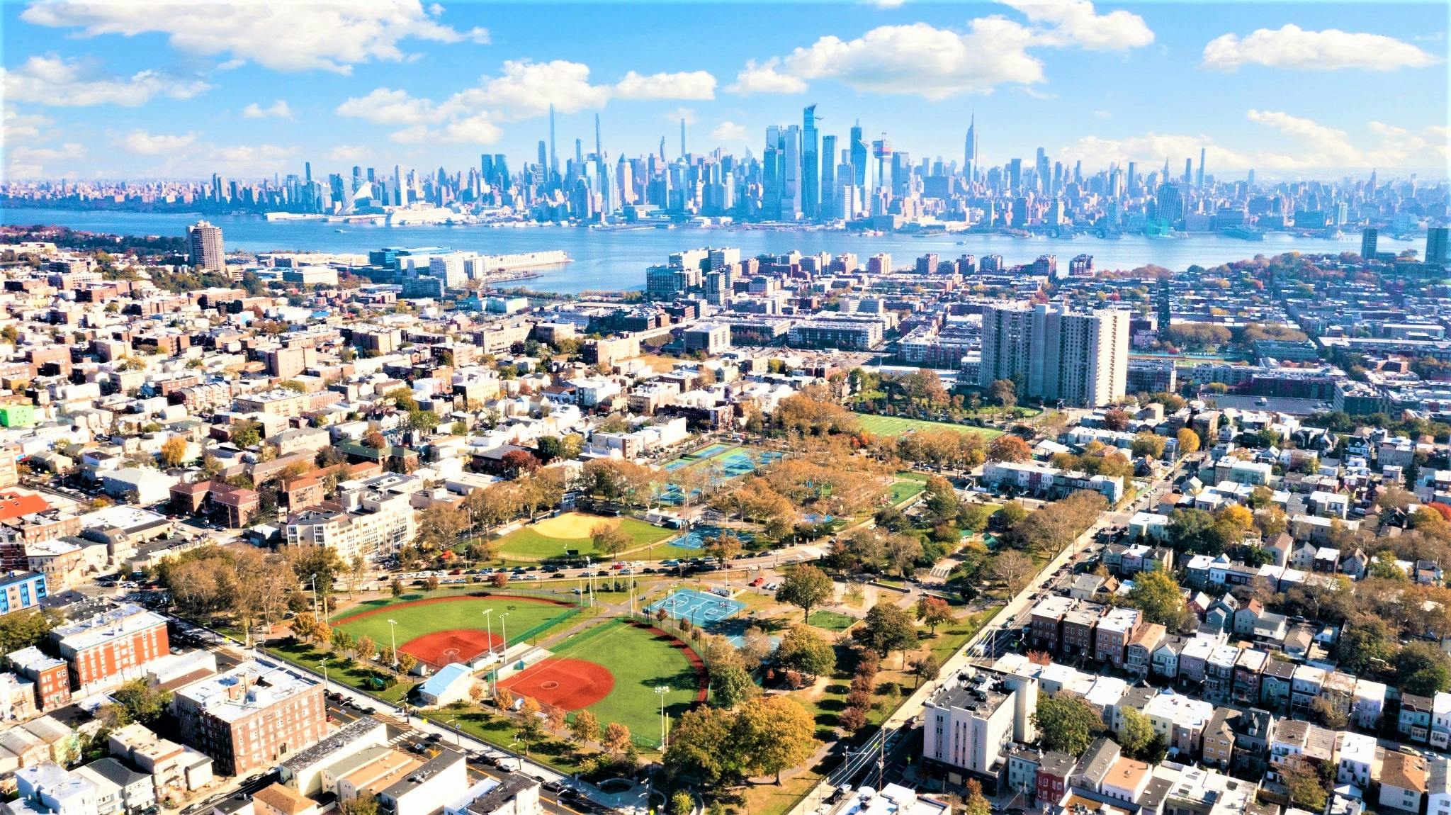Aerial view of a city with a park and distant skyline across water