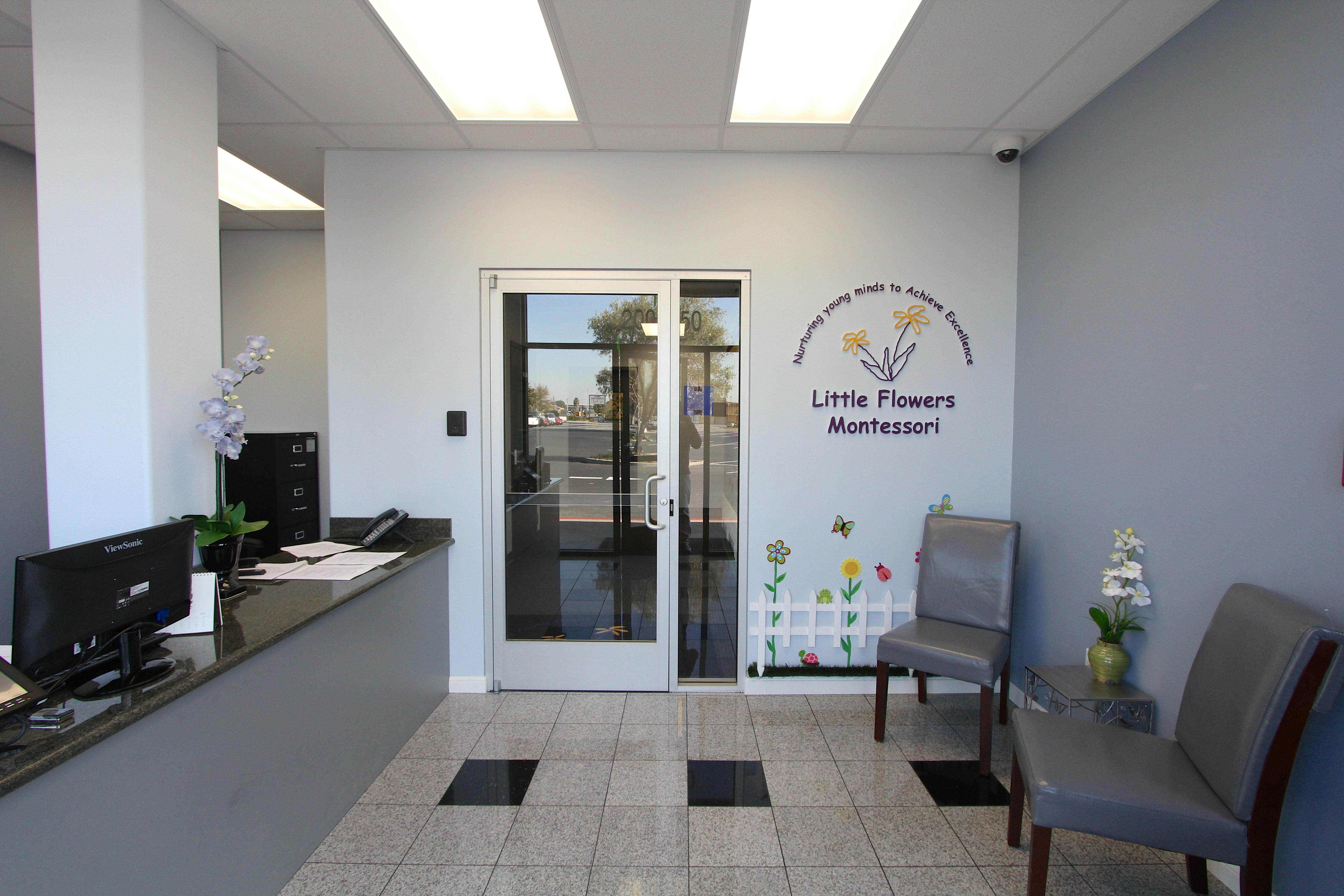 Reception area with a desk, computer, and glass doors
