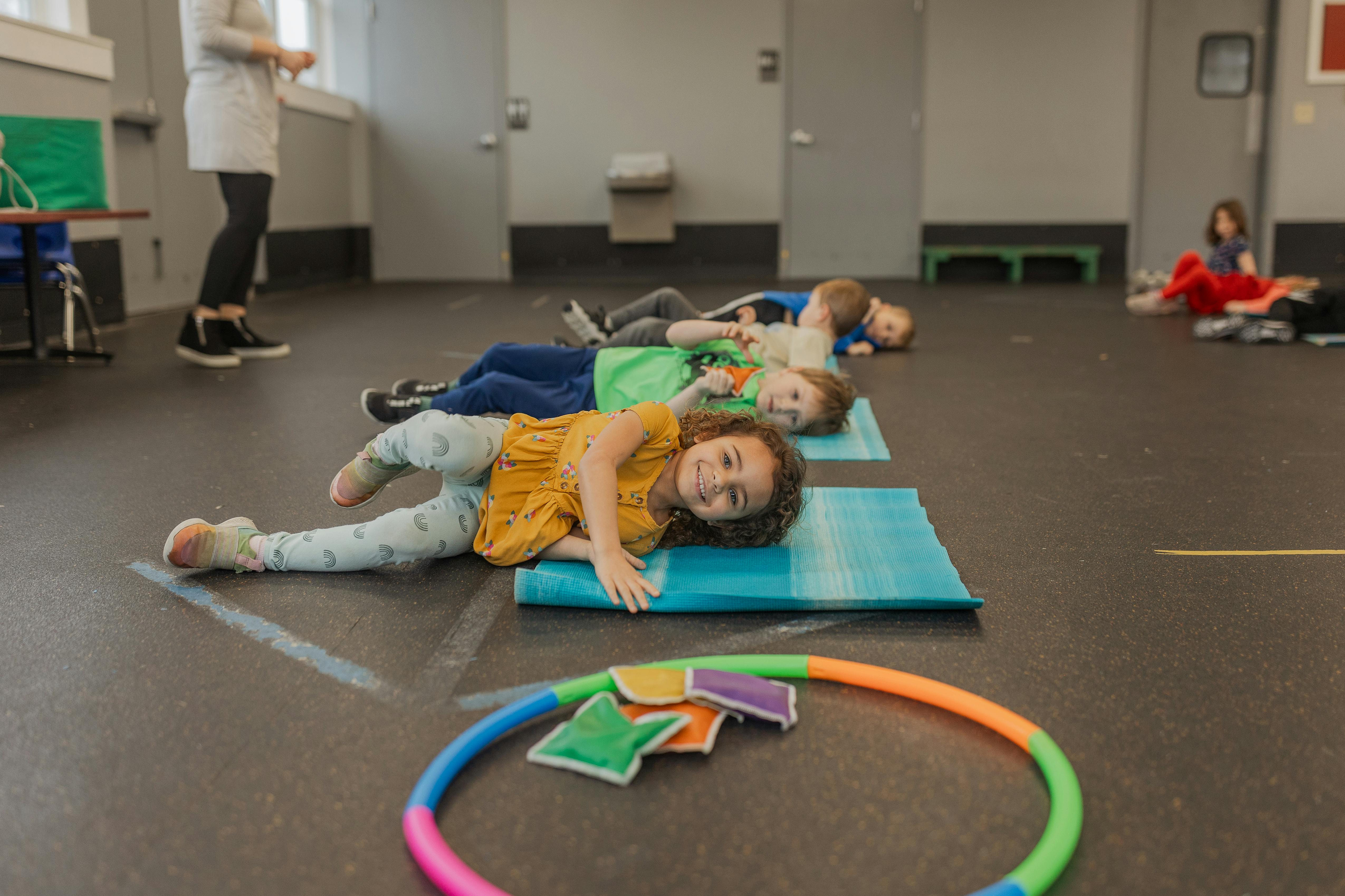 Children lying on yoga mats in a classroom