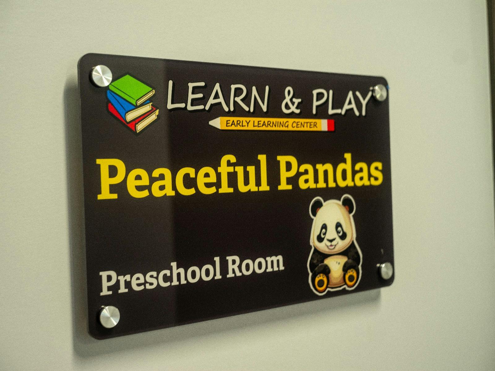 Sign for "Peaceful Pandas Preschool Room" with a panda illustration