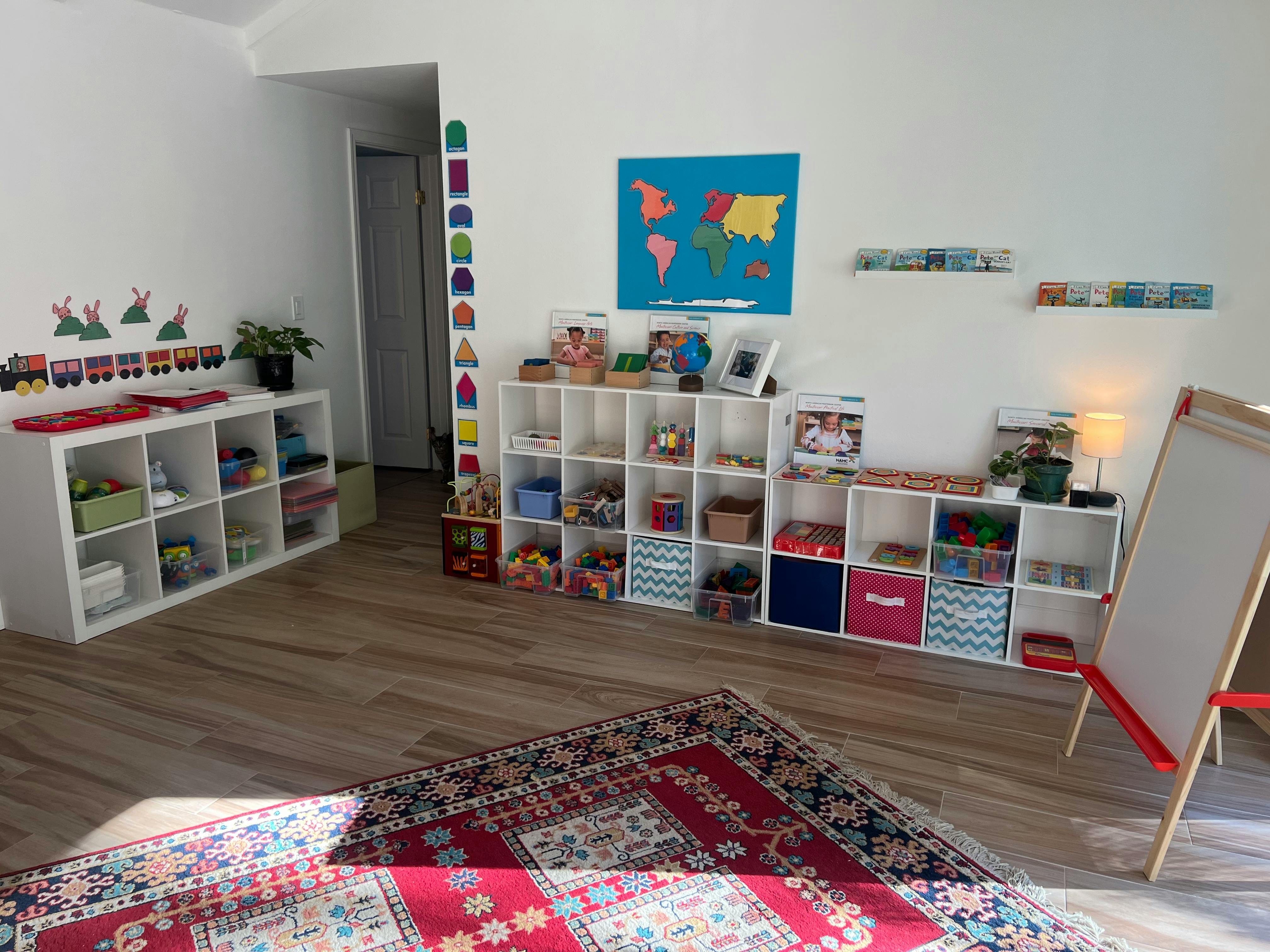 Classroom with shelves of learning materials, a world map, and an easel