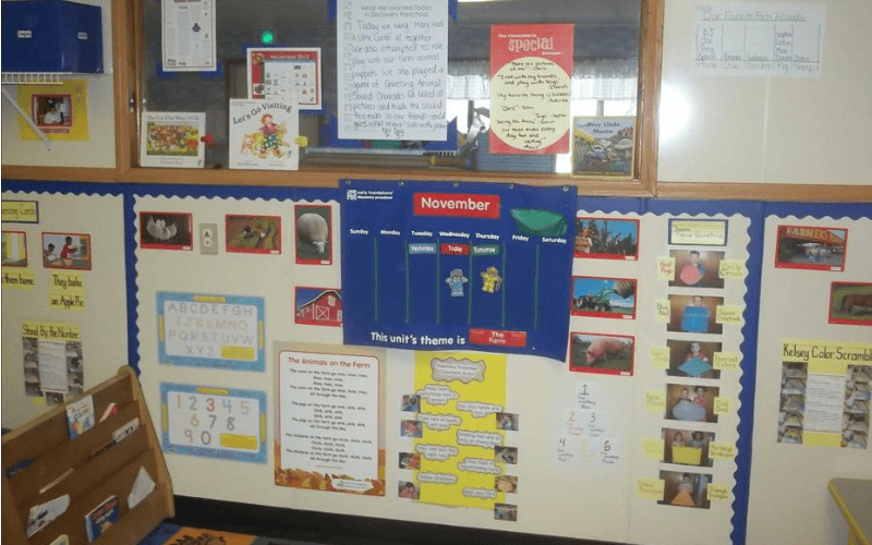 Classroom wall with a blue calendar, alphabet, numbers, and farm-themed displays