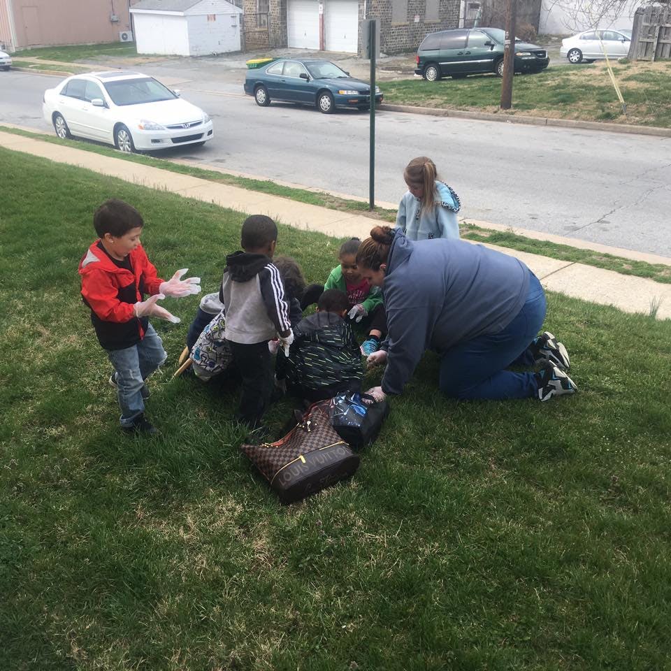 Adult and children on grass next to a street