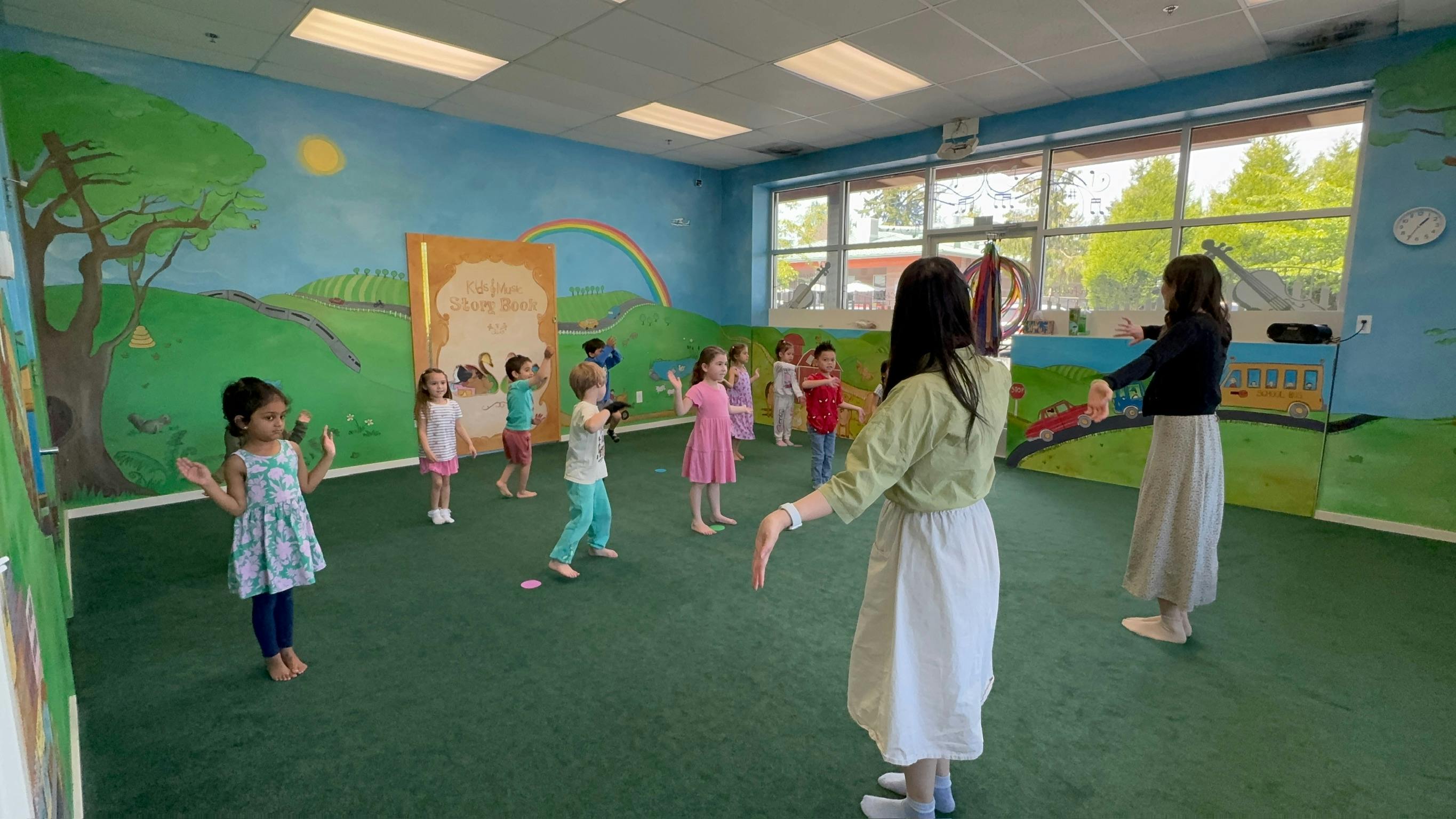 Children and adults in a classroom setting, hands raised, playing a game
