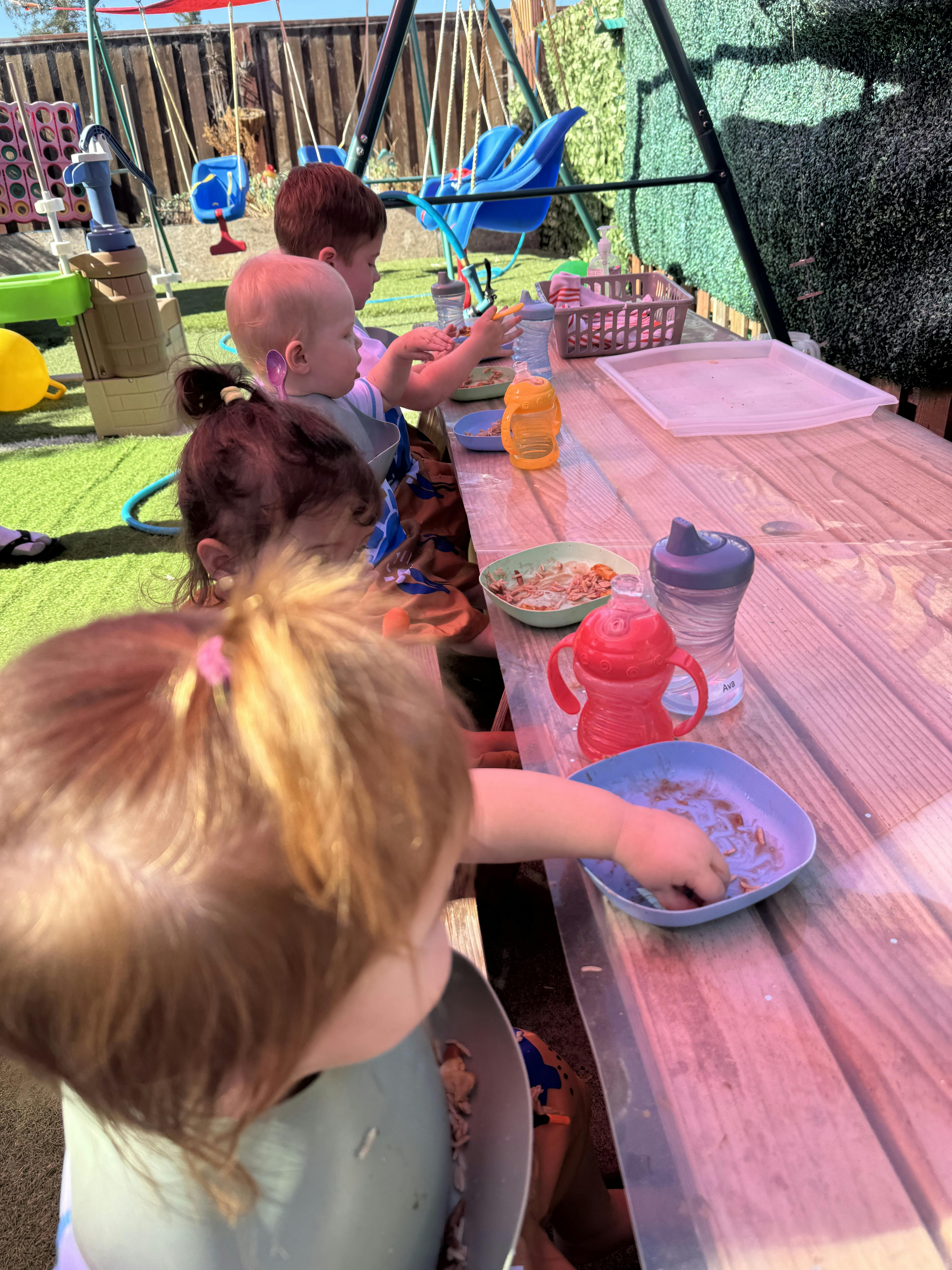 Group of children eating at an outdoor table