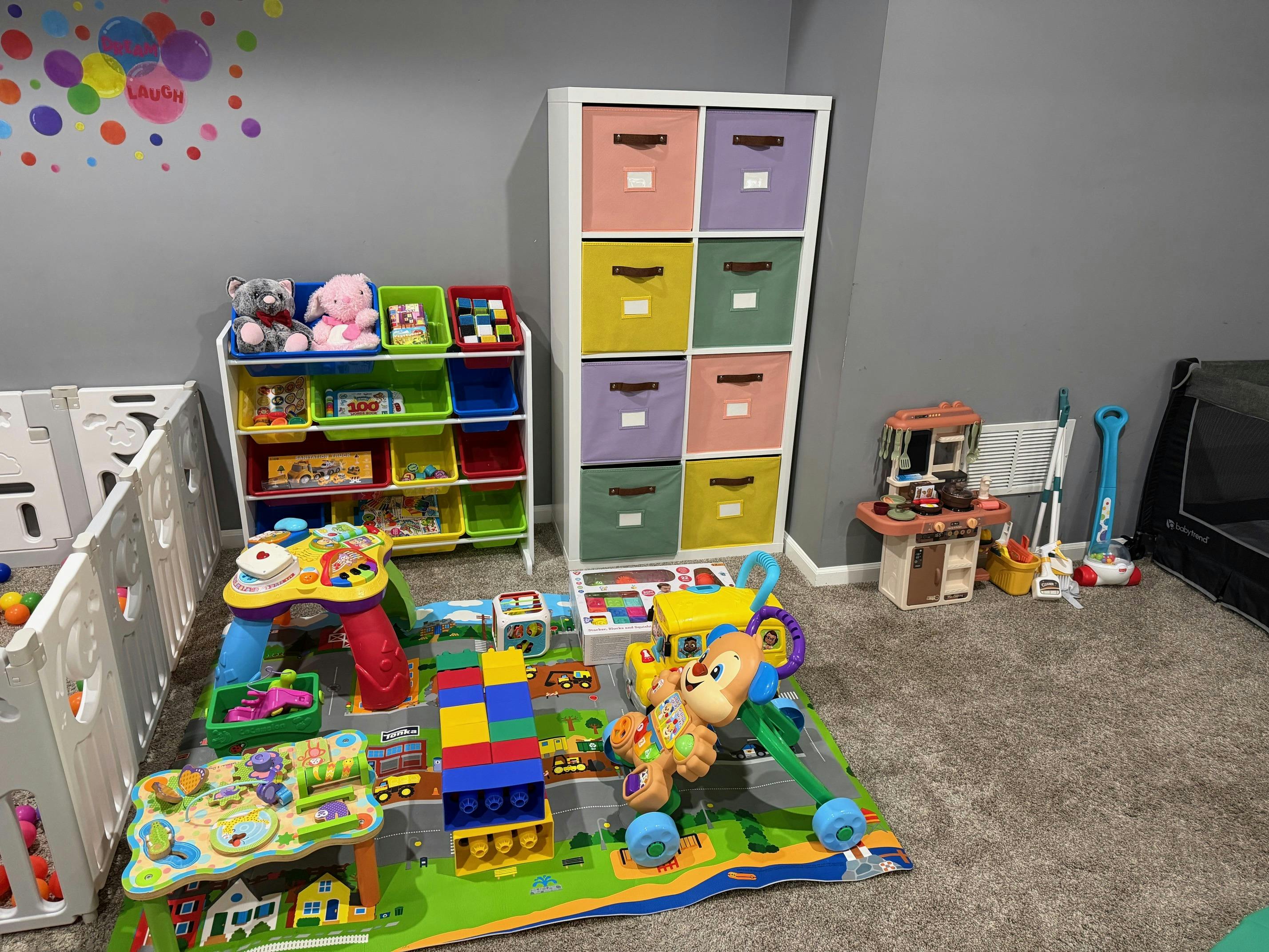 Playroom with various toys, storage bins, and a playpen