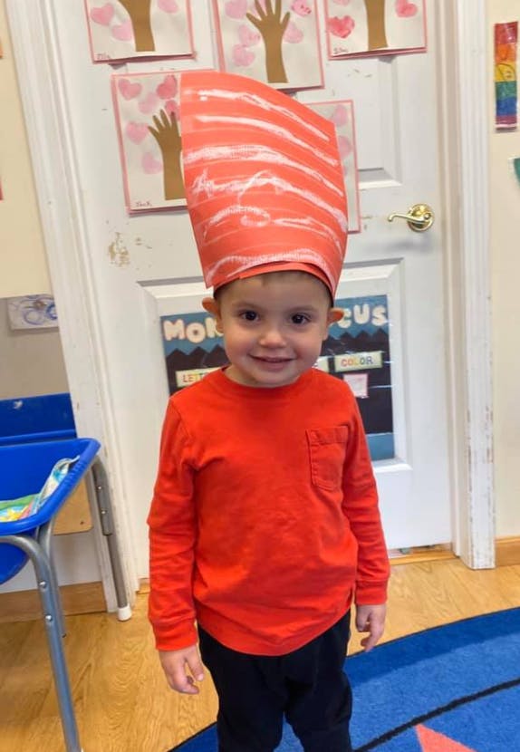 Child wearing a tall red and white striped hat