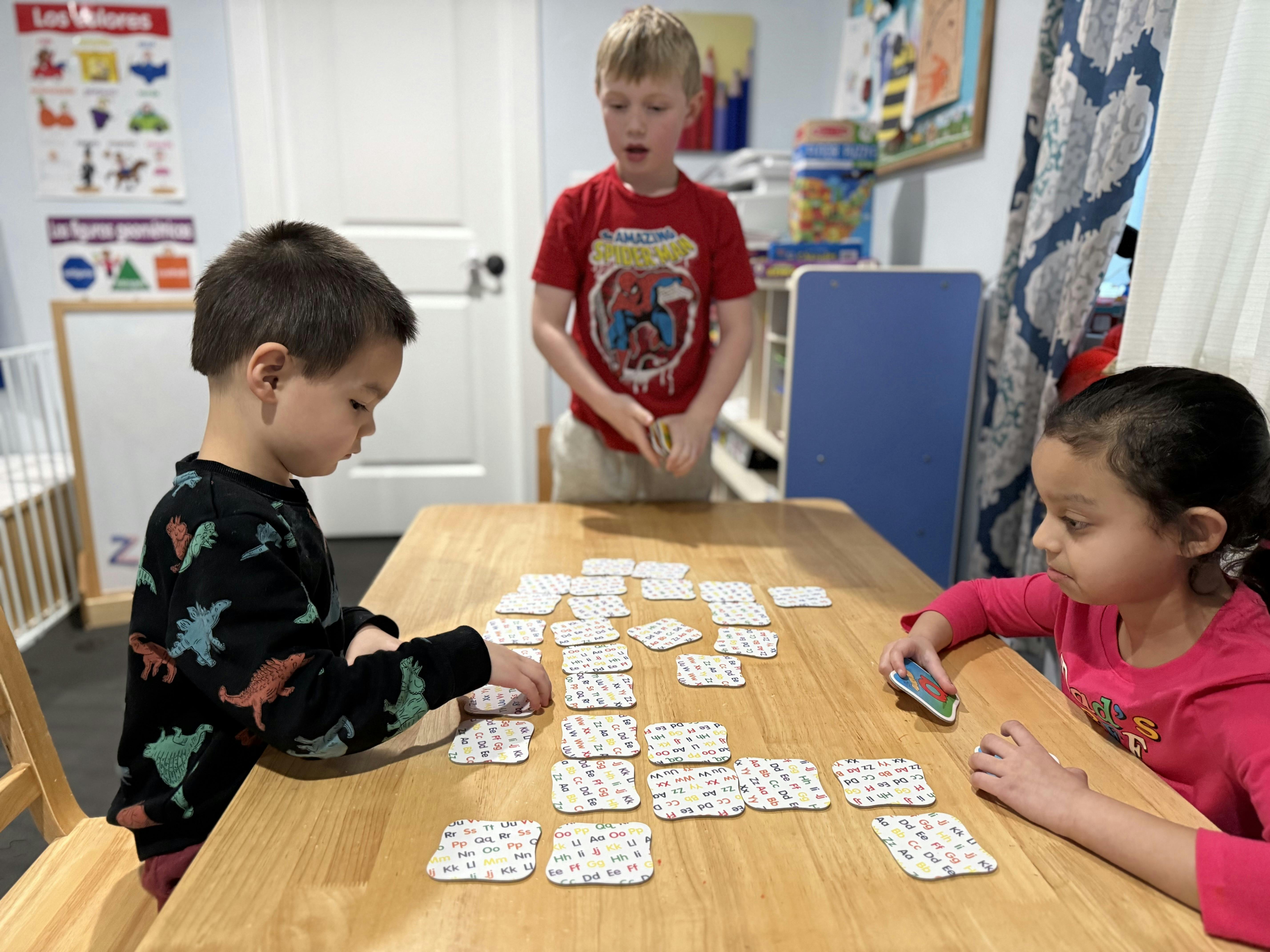 Three children playing a card game at a table