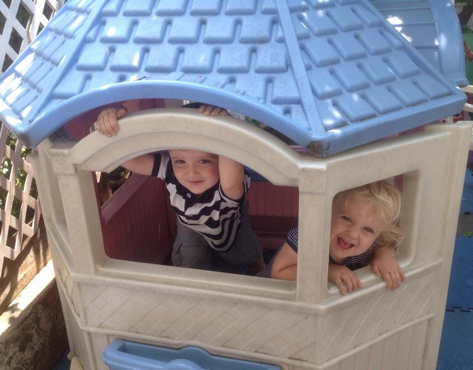 Two children looking out from a playhouse