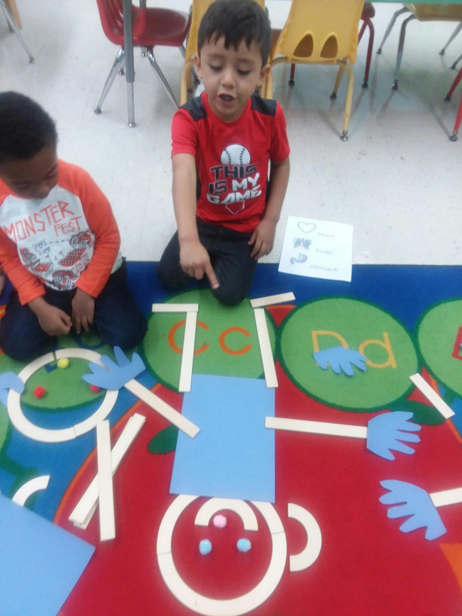 Two children on a colorful rug with craft materials