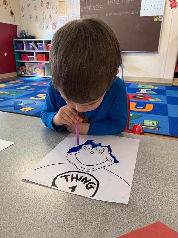 Child coloring a drawing of Thing 1 from Dr. Seuss