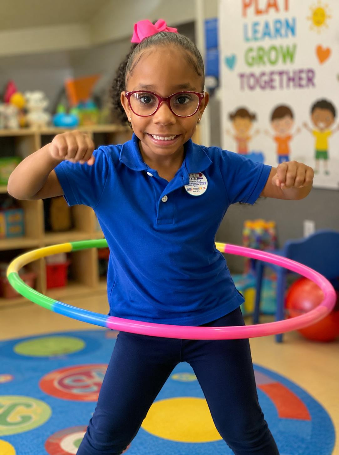 Child playing with a hula hoop in a classroom