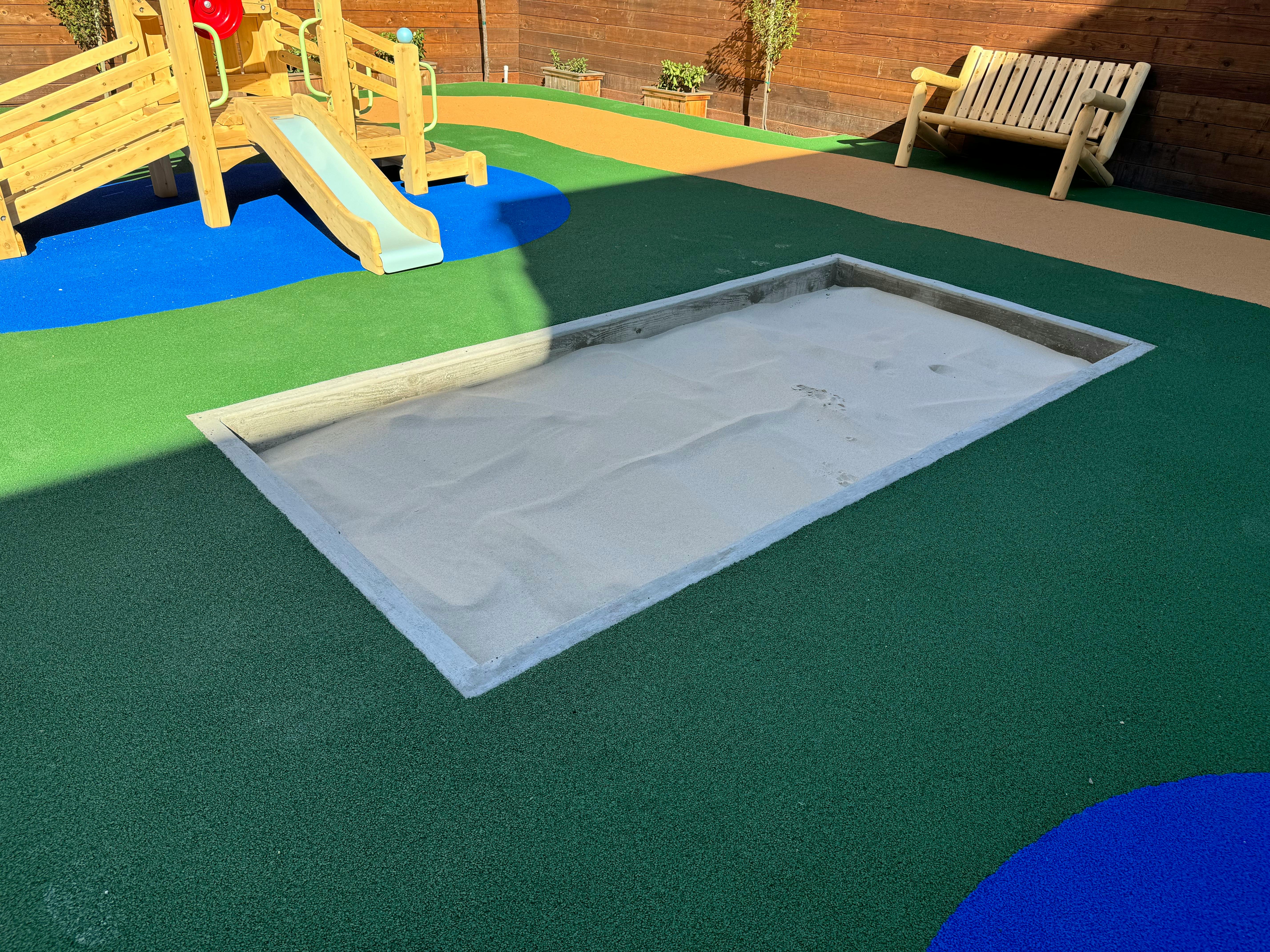 Playground with a sandbox, slide, and bench