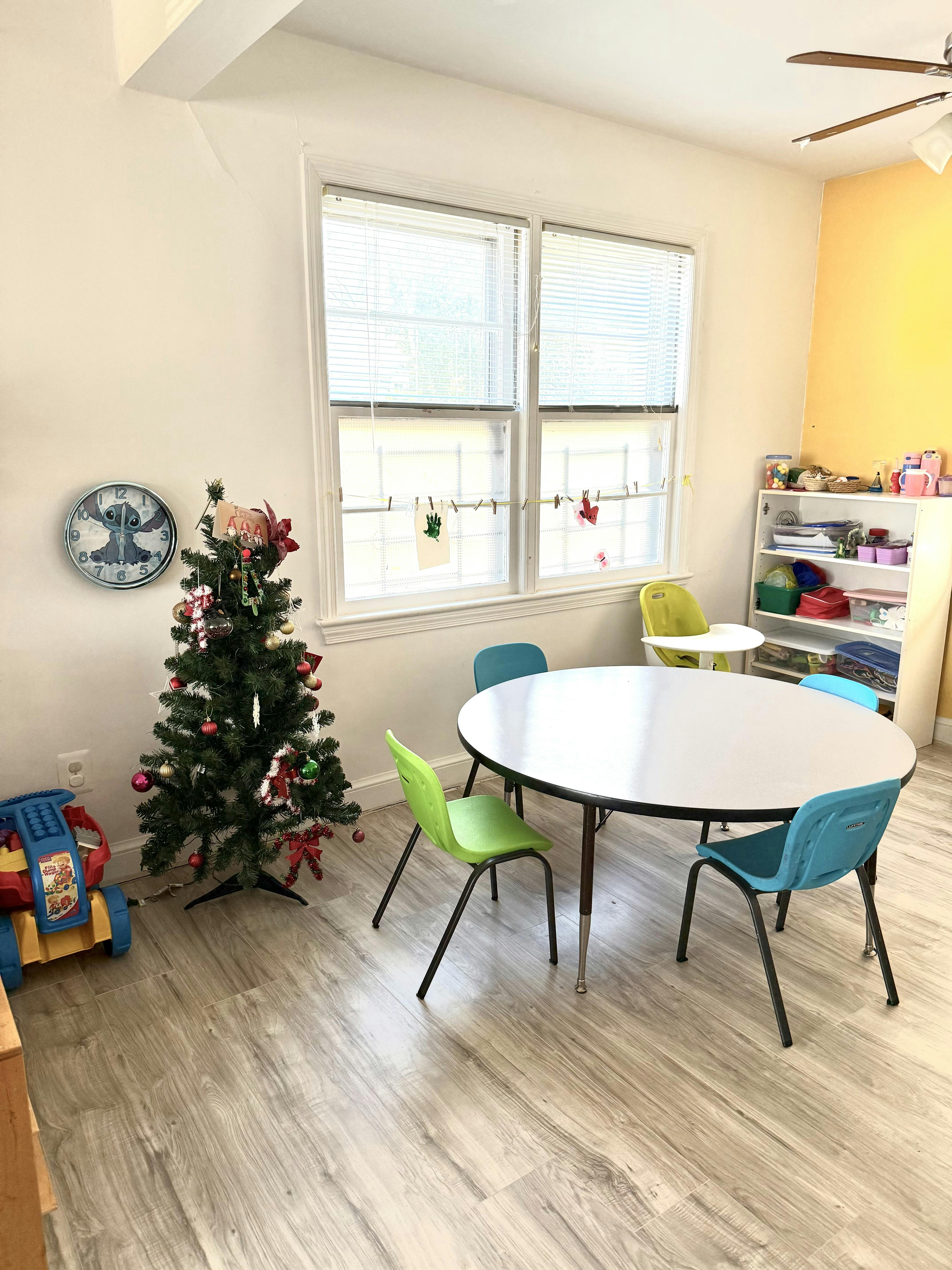 Children's play area with a small Christmas tree and a round table with chairs