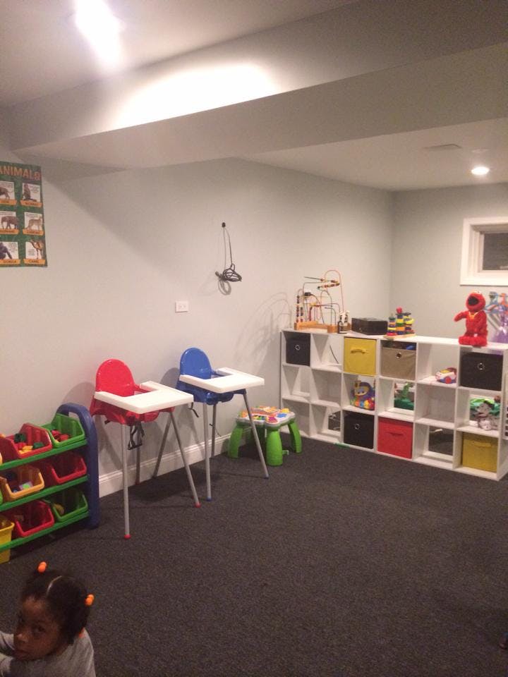 Child in a playroom with high chairs and toy storage