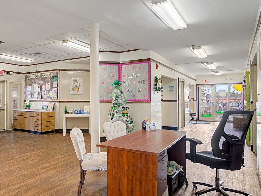 Reception desk with office chair in a brightly lit hallway