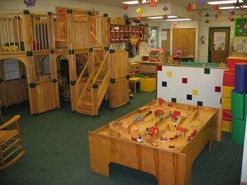 Indoor playground with wooden structures and a sand table