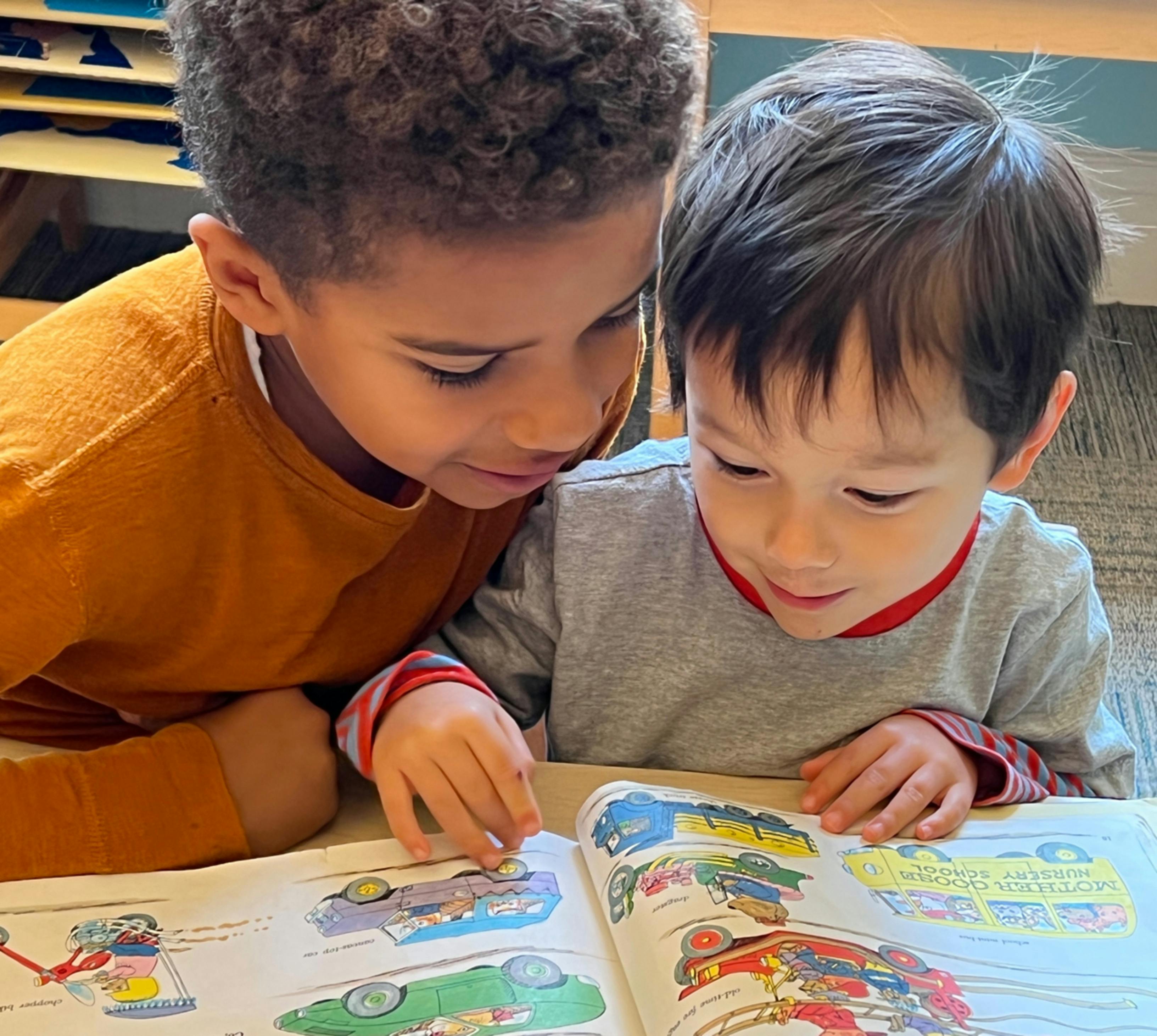 Two children looking at a book together