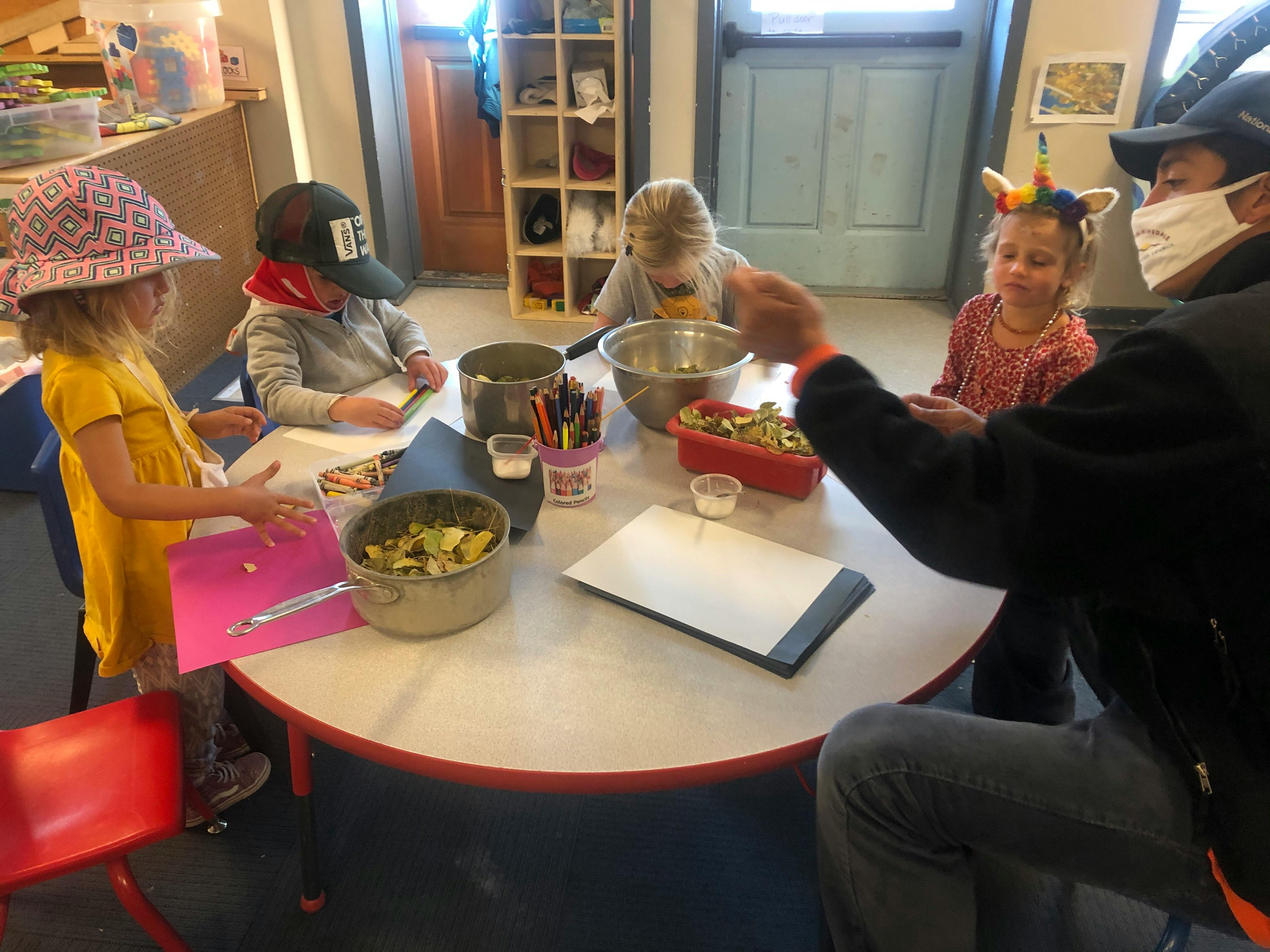 Adult and three children at a table with bowls of food