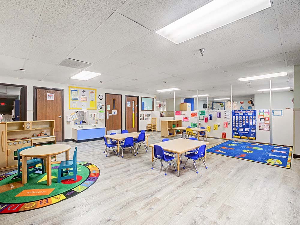 Empty colorful children's classroom with small tables and chairs