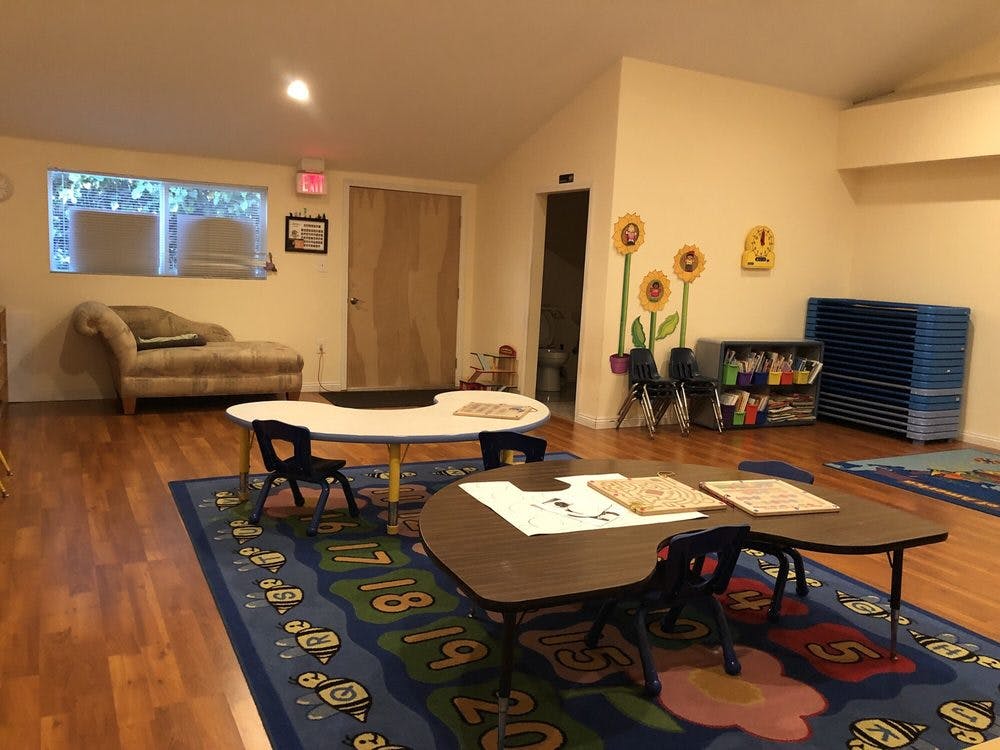 Classroom with small tables and chairs on a number rug